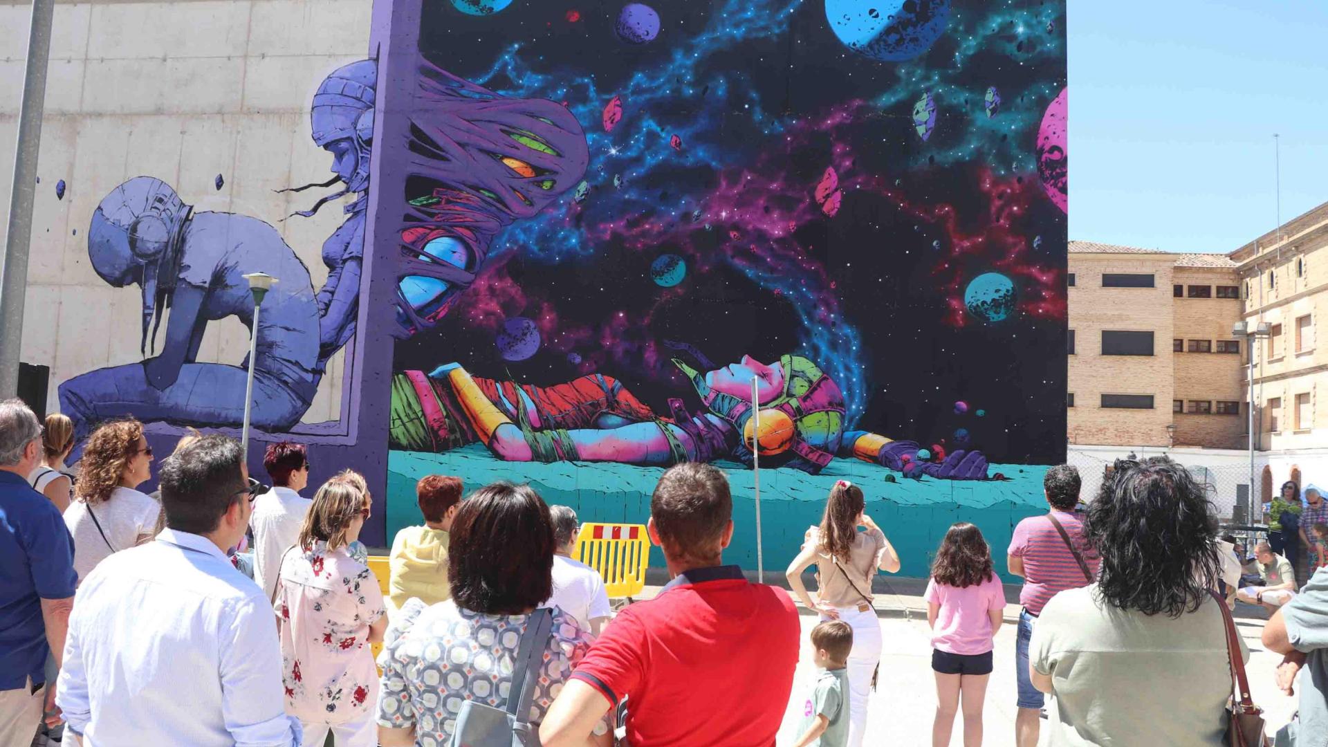 El público observa uno de los murales que se han realizado en el festival.