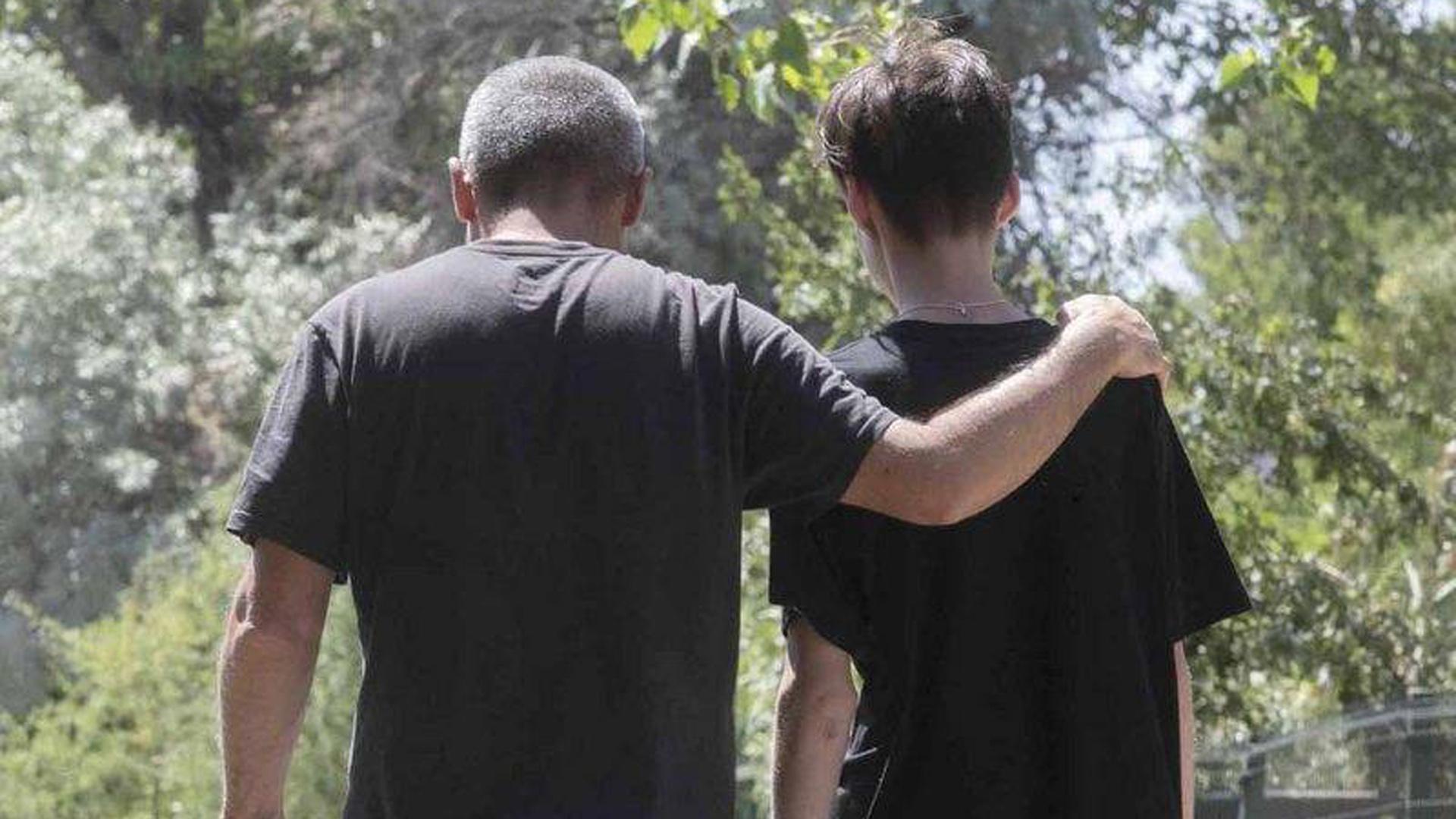 Un padre y un hijo pasean por un camino