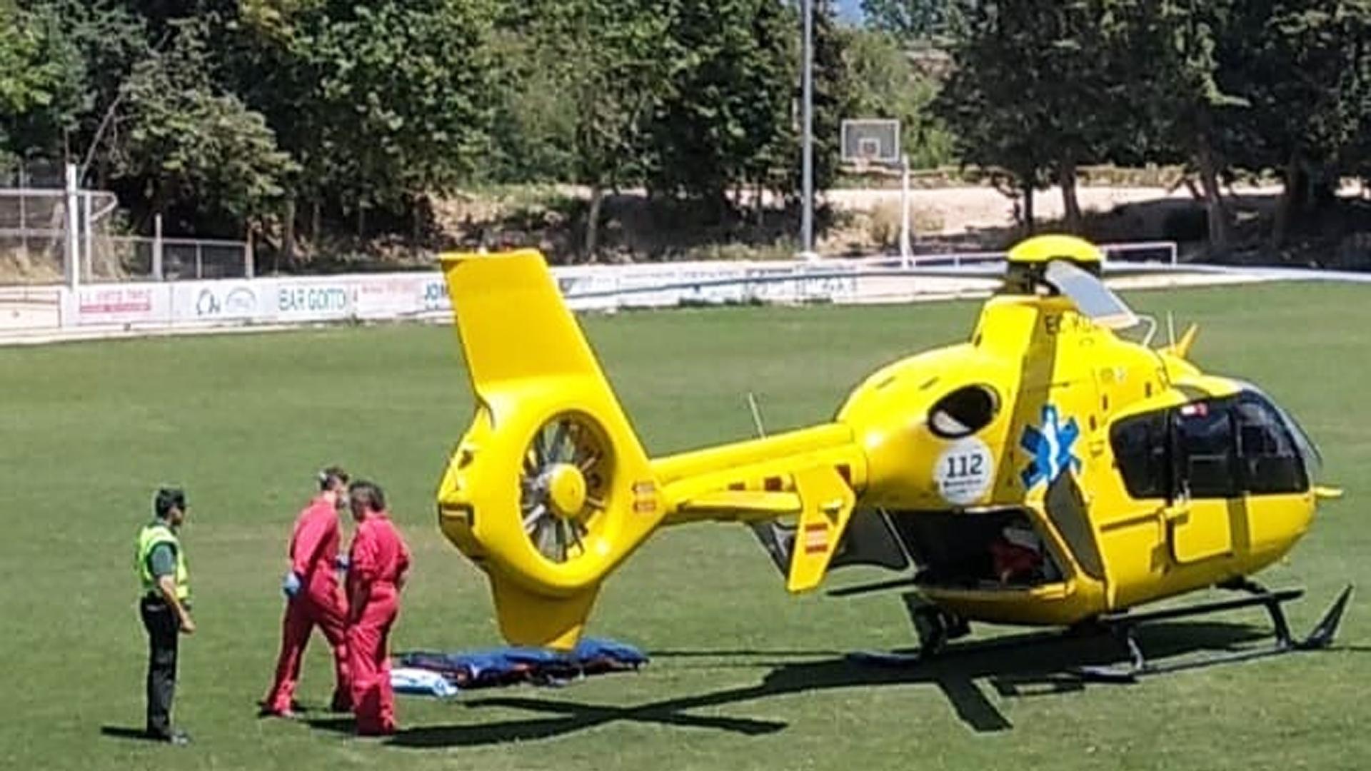 Un agente de la Guardia Civil junto a sanitarios en el césped del campo de fútbol de Miranda de Arga donde aterrizó el helicóptero