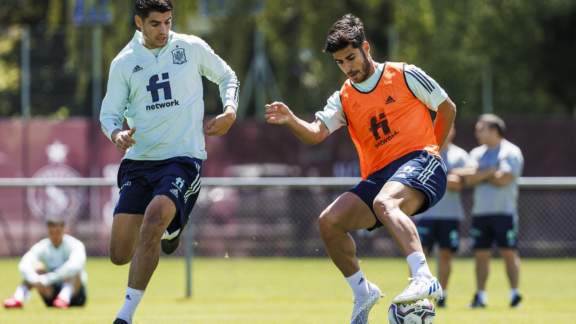 Marco Asensio (dcha.) pisa el esférico ante la prresión de Álvaro Morata durante el entrenamietno de la selección española este martes en Ginebra