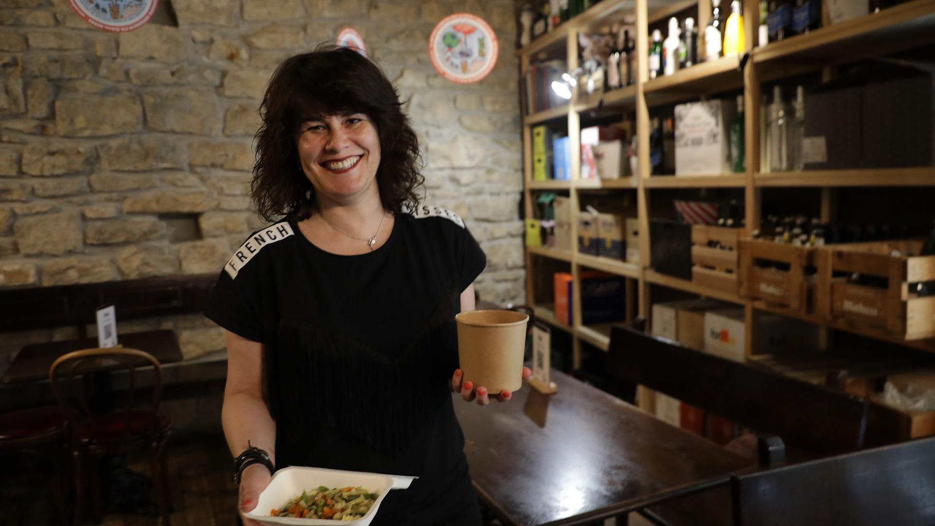 Natalia Ecay, dueña del restaurante La Antigua Farmacia, sujeta dos envases con comida para llevar