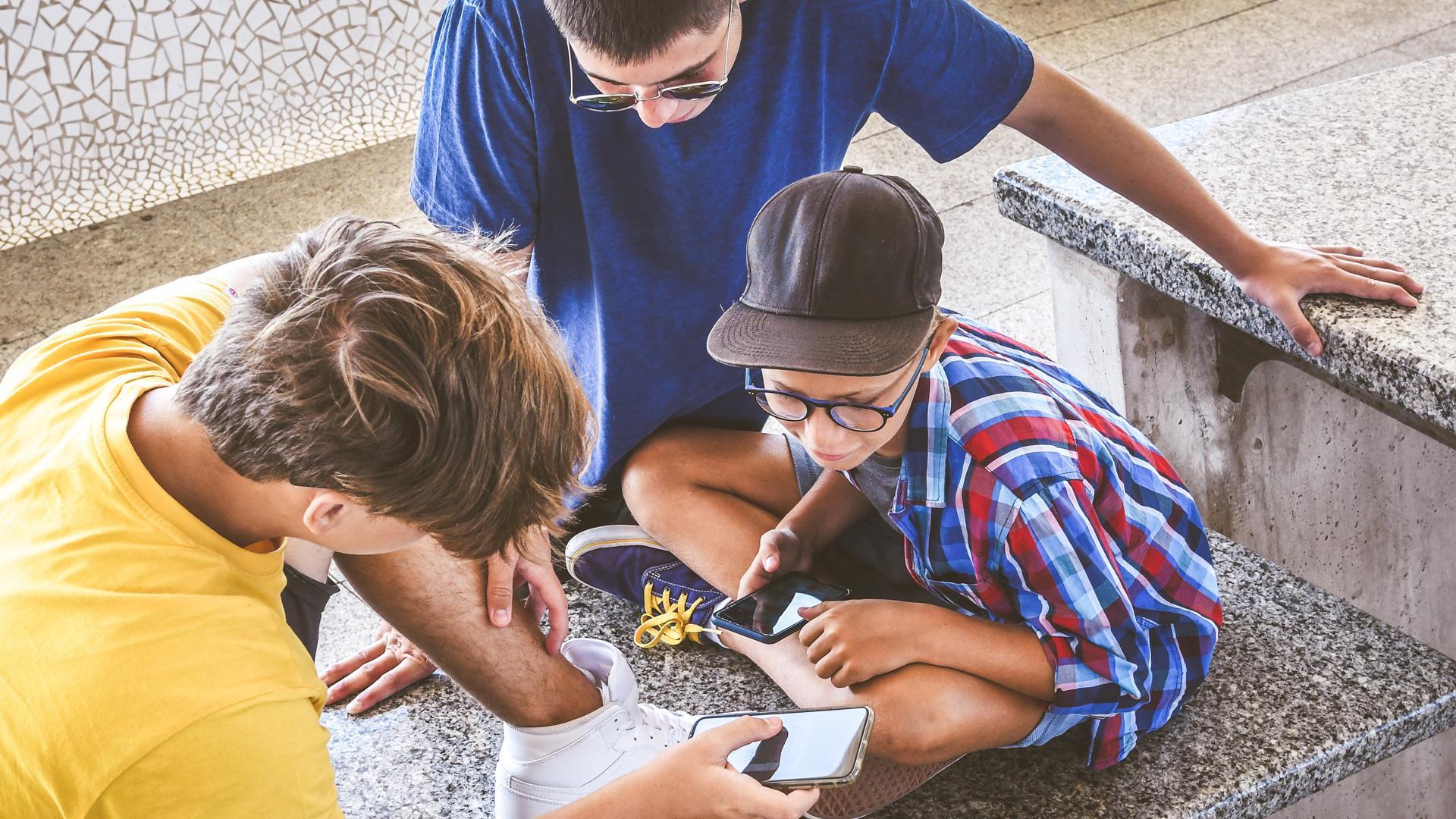 Varios adolescentes consultan el móvil