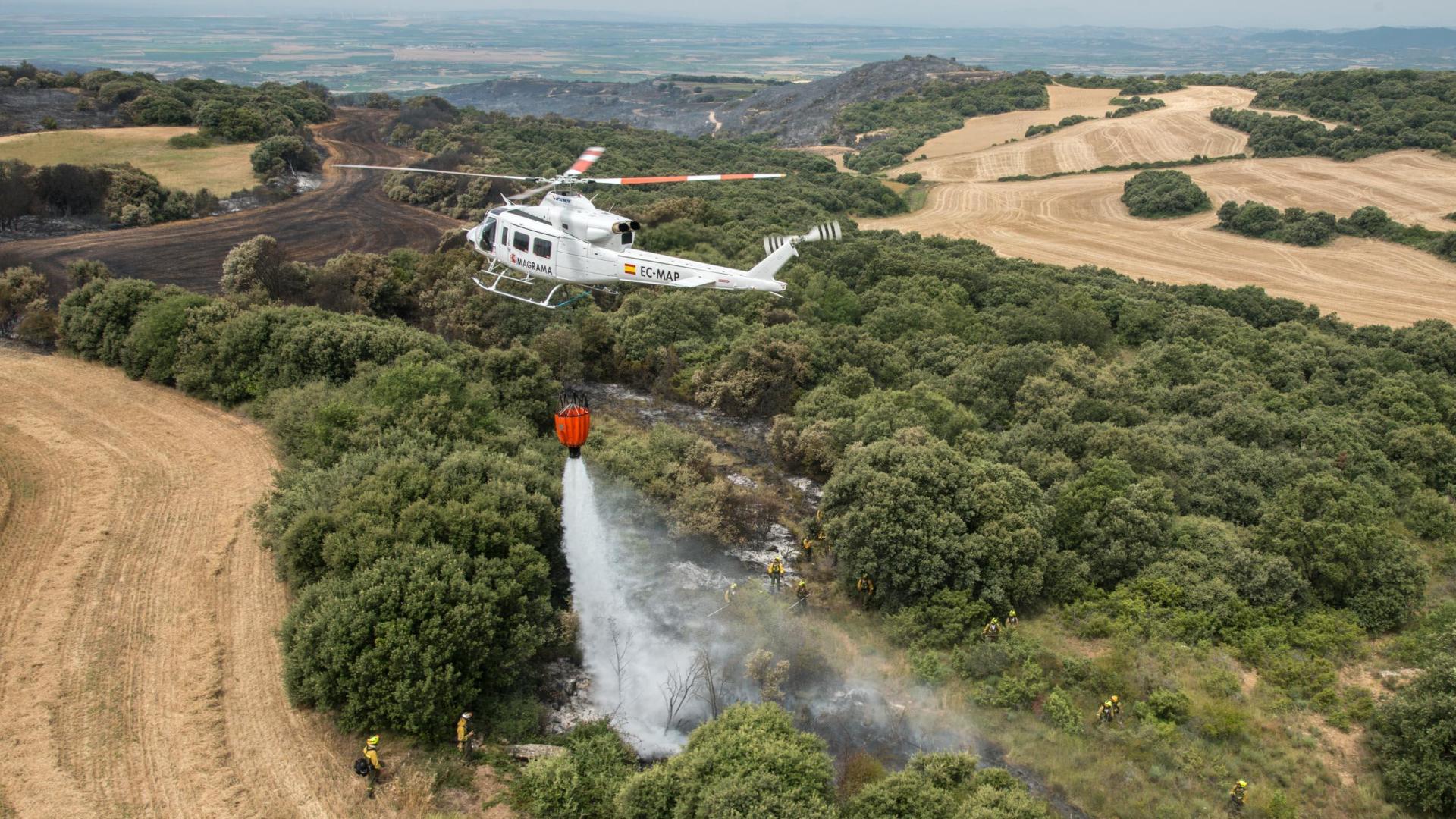 Un helicóptero vierte agua para sofocar el fuego, en un incendio anterior