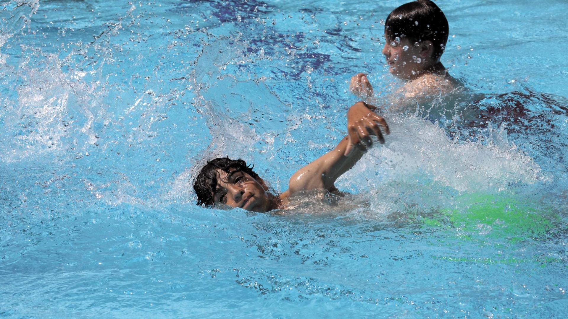 Dos jóvenes nadan en las piscinas de Aranzadi estos días de intenso calor.