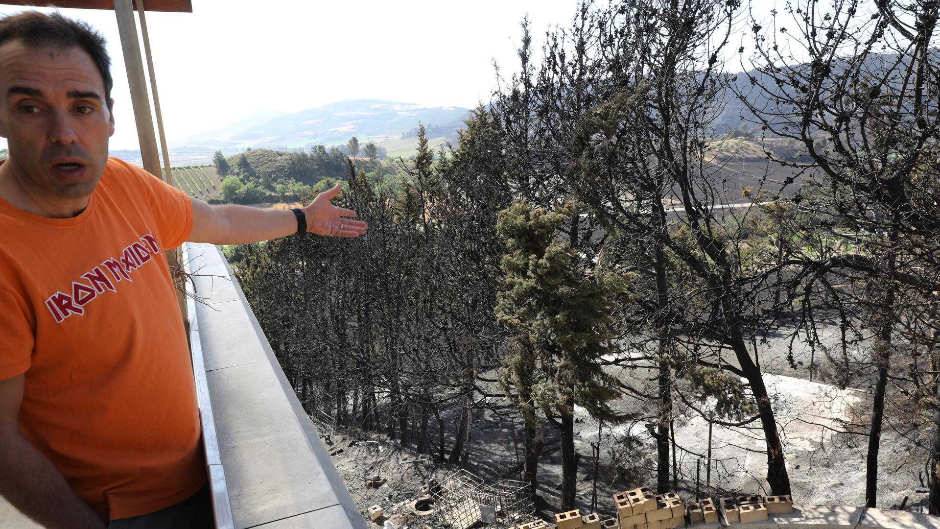 Pablo San Martín muestra el terreno afectado en Obanos por el incendio del sábado, que quemó la casa de al lado y prendió el jardín y una terraza con césped artificial de la suya
