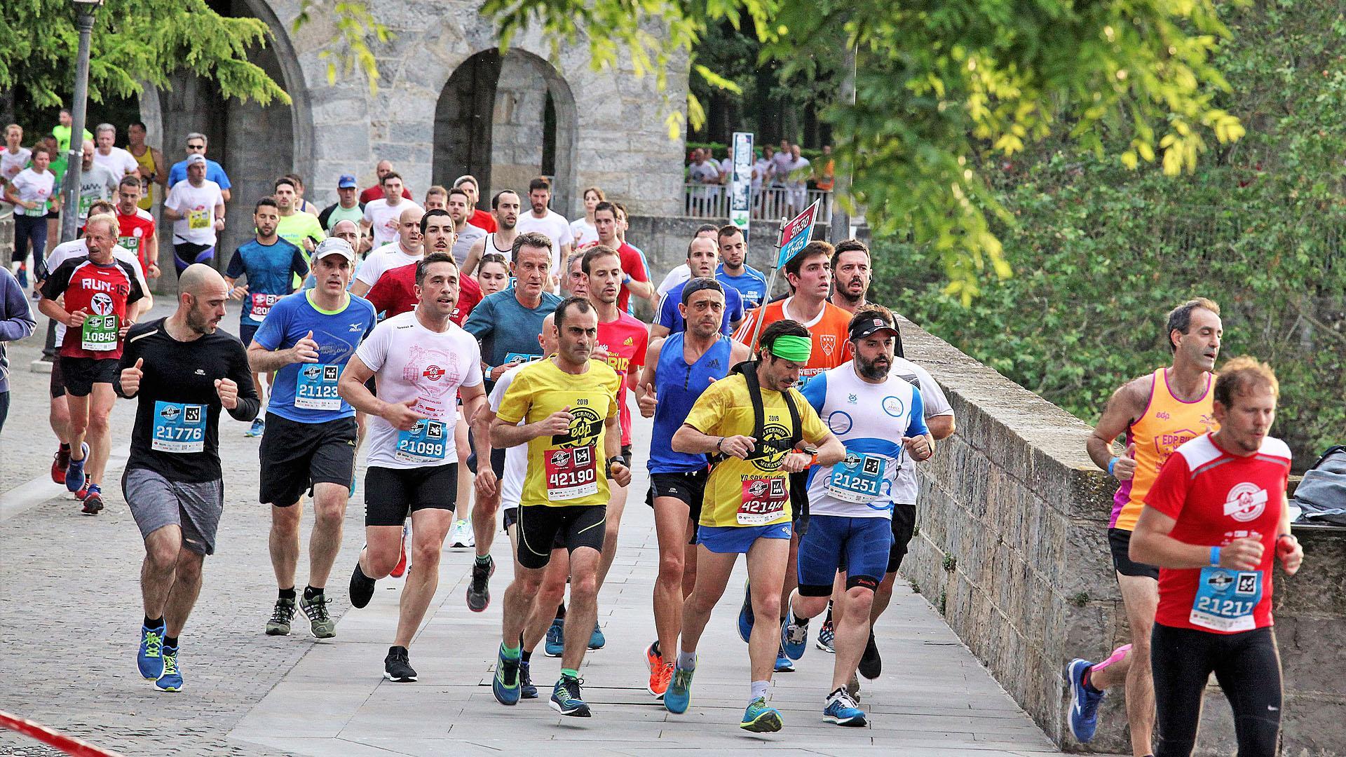 Un grupo de corredores en la San Fermín Media Maratón de 2019 cruzando el Portal Nuevo, una zona por la que volverán a pasar mañana los recorridos de La Media San Fermín