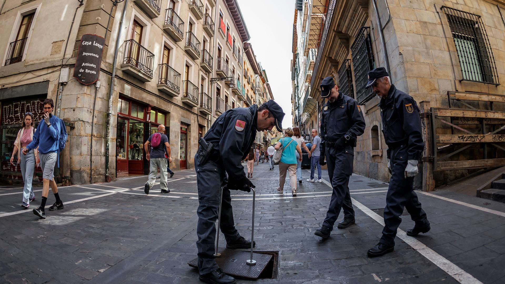 -Efectivos de la Unidad de Subsuelo de la Policía Nacional cierran la tapa de acceso de la calle Estafeta a los túneles del alcantarillado de Pamplona después de comprobar su interior.