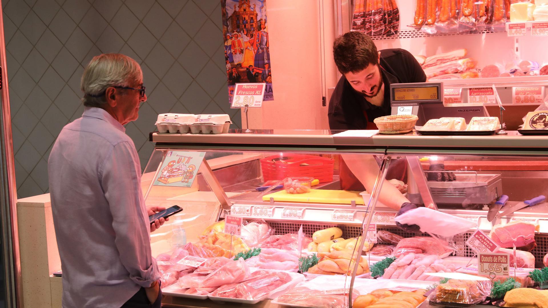 Un carnicero atiende a un cliente en la zona del mostrador del establecimiento donde se expone la carne de pollo