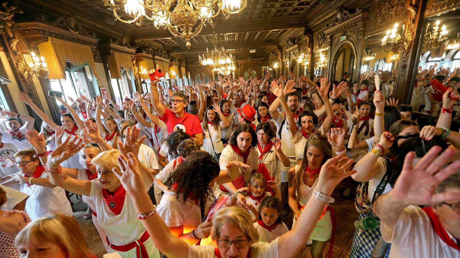 Con los brazos alzados un buen grupo de personas bailan las canciones en el salón del Nuevo Casino