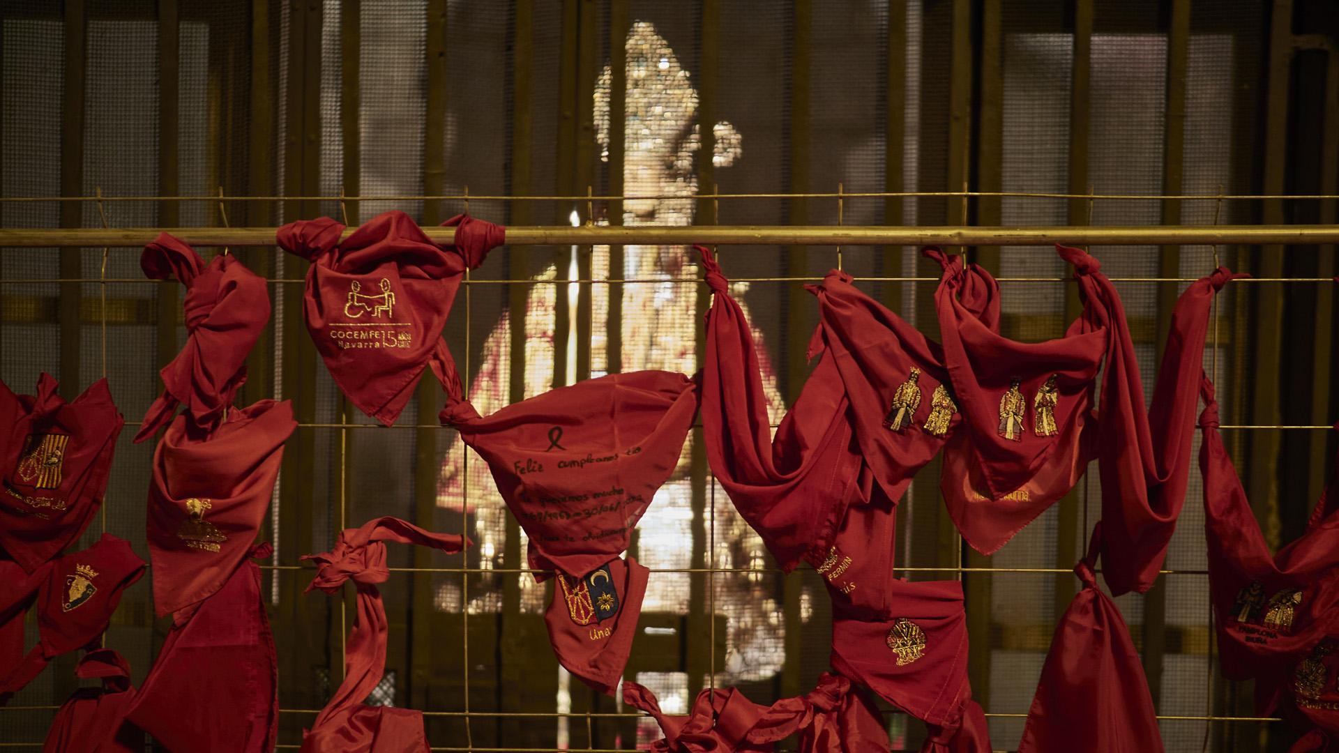 Varias personas dejan su pañuelo en la puerta de la capilla de San fermín en la parroquia de San Lorenzo para despedir los Sanfermines 2022