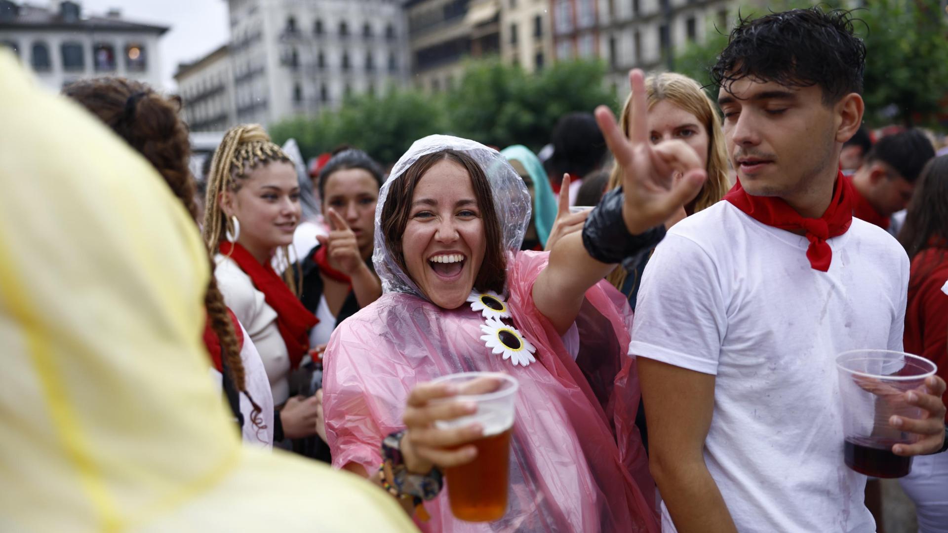 Dos jóvenes, bebida en mano, en la plaza del Castillo tras el Chupinazo