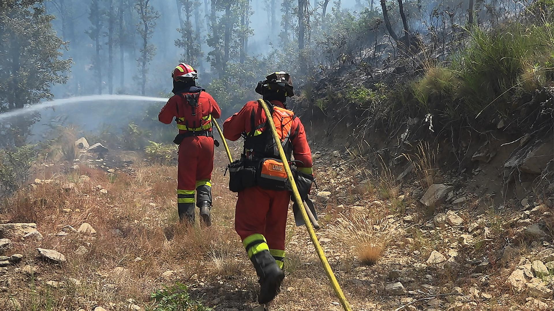 Dos efectivos de la Unidad Militar de Emergencias (UME) colaboran en la extinción del fuego en el Jerte