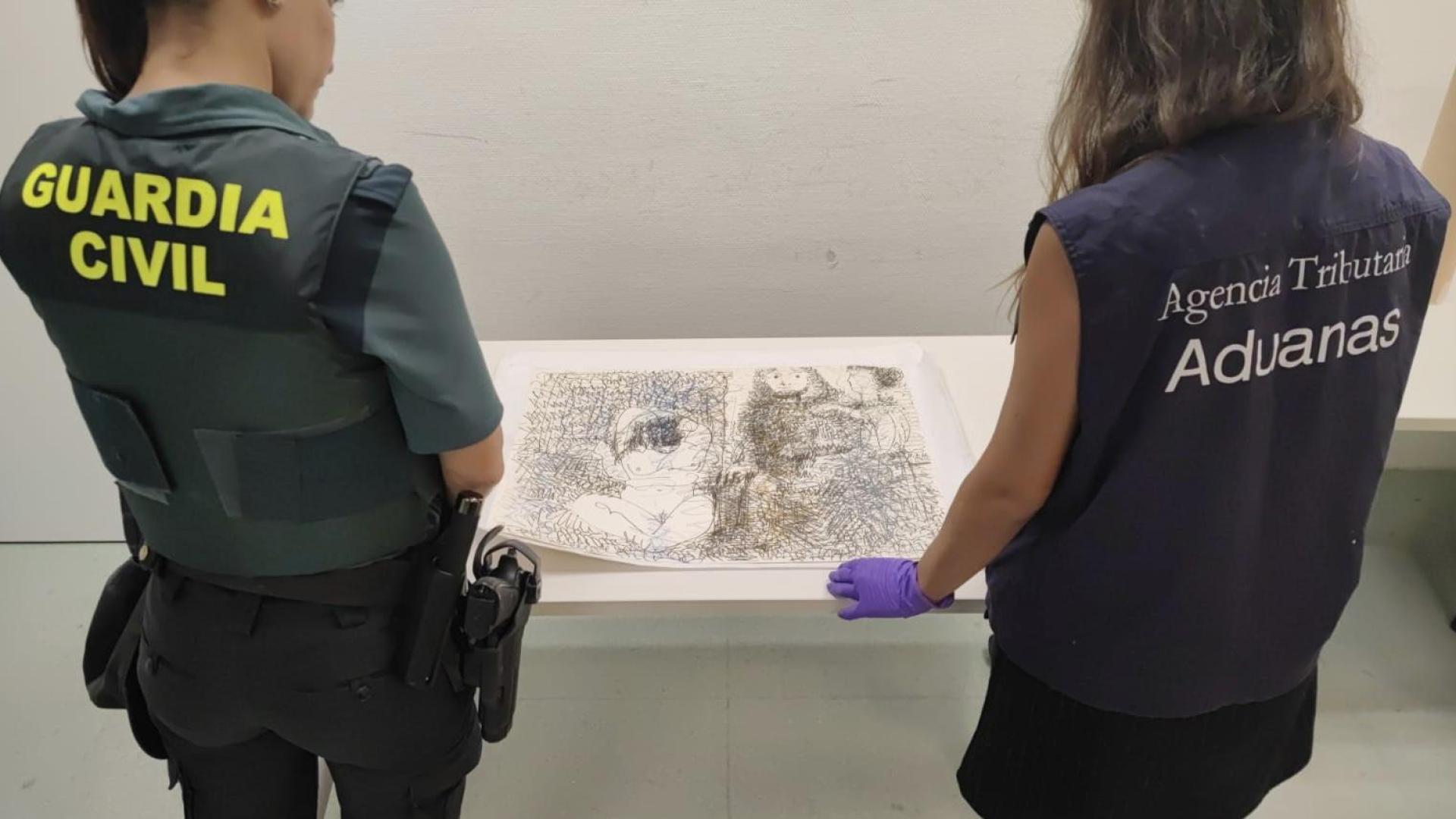 Dos agentes, de la Guardia Civil y Aduanas, junto a la obra "Trois personnages" (1966) que se encontraba en el equipaje de un viajero procedente de Suiza
