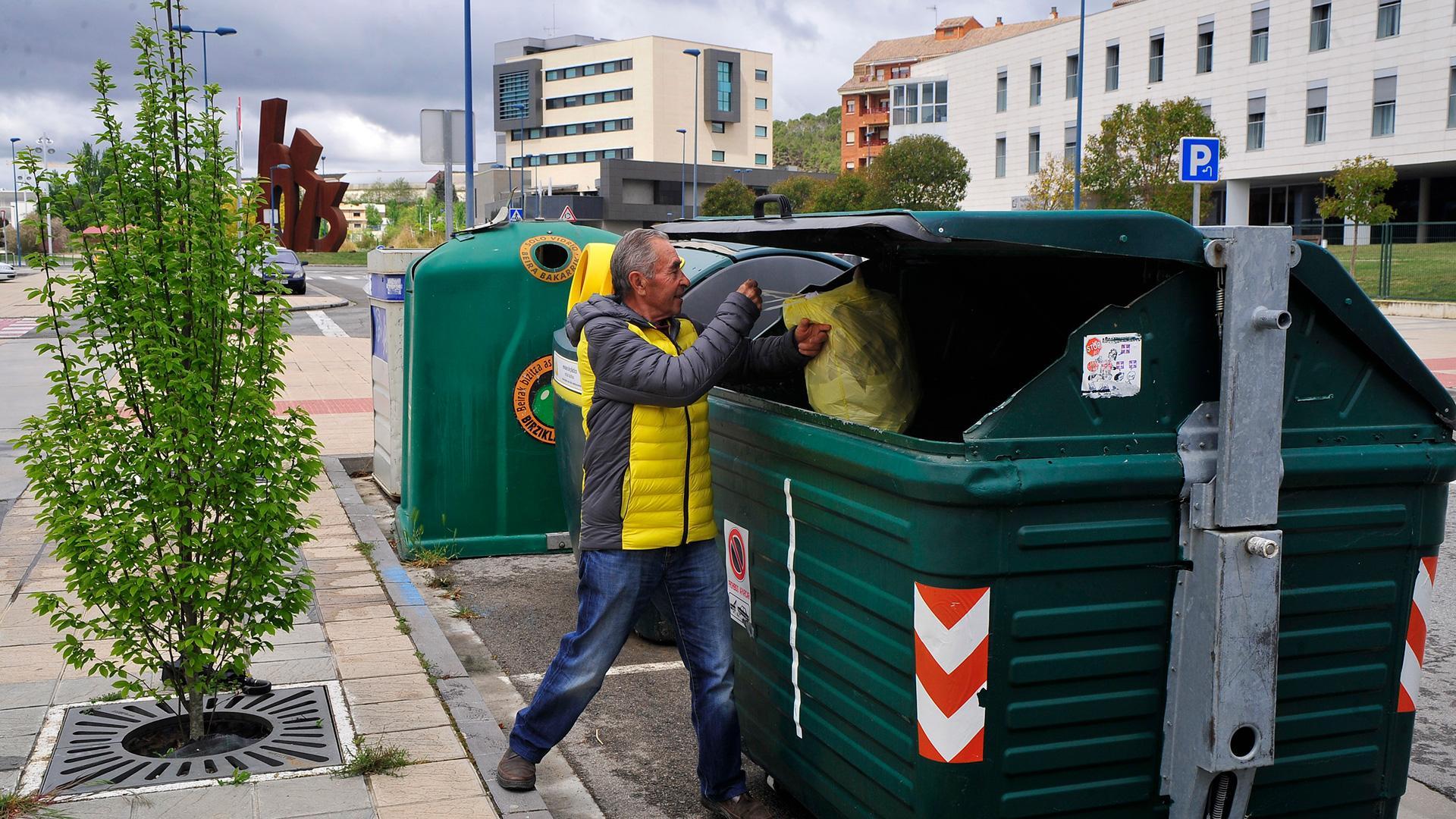 Un vecino de Tafalla deposita una bolsa de basura en un contenedor