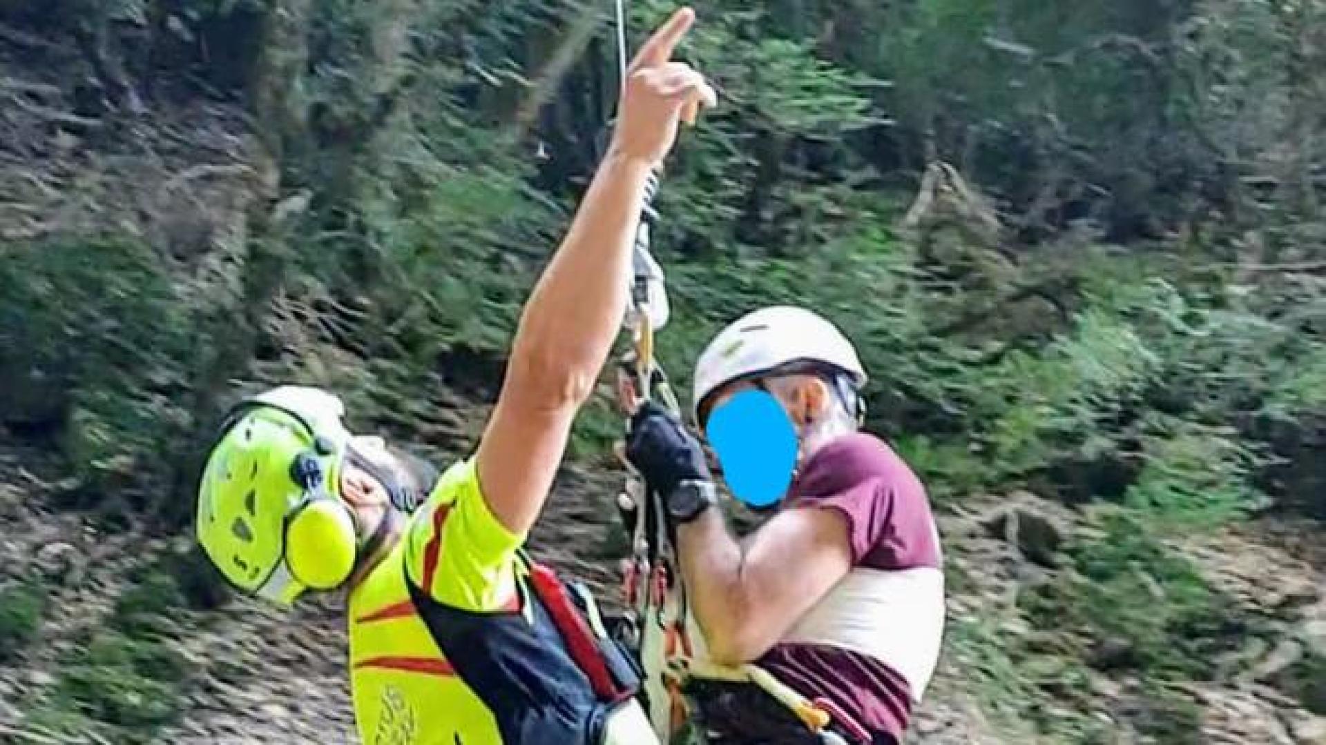 Un momento del rescate en el que bombero y herido son izados del barranco por el helicóptero