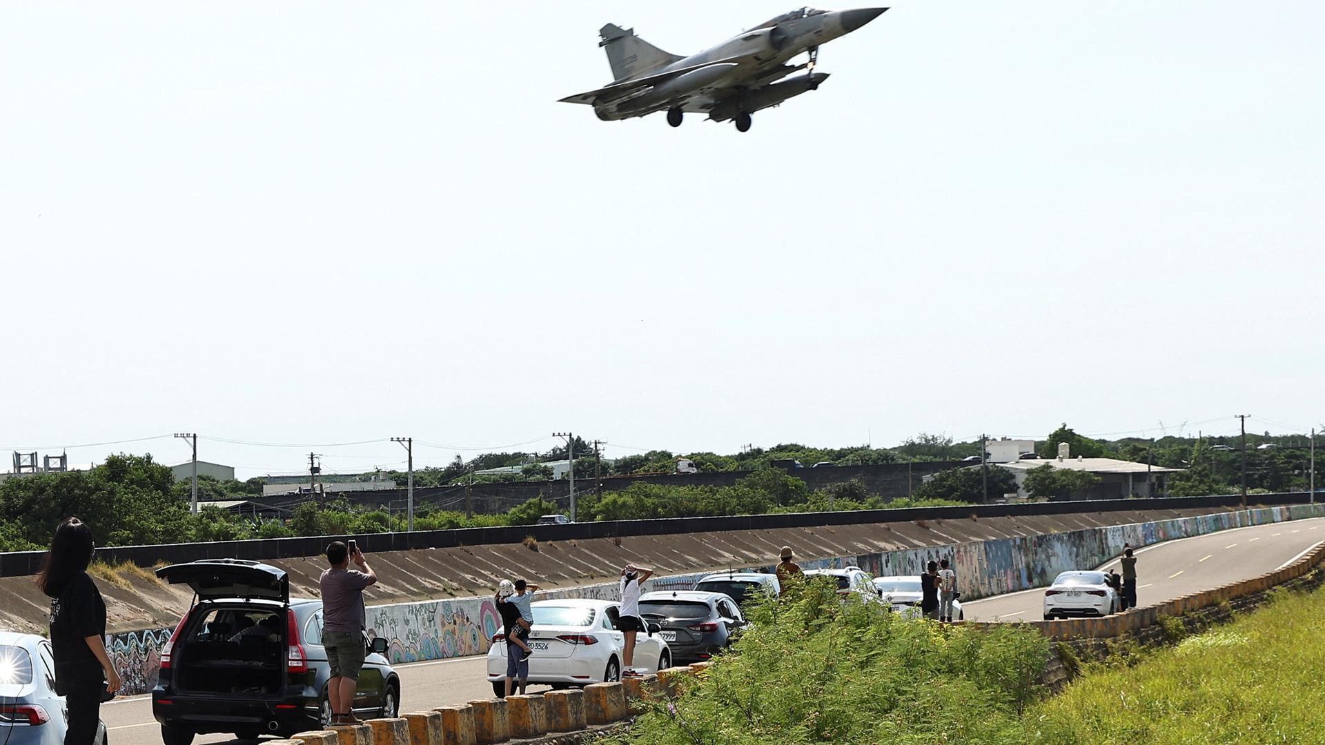 La gente observa cómo un avión Mirage 2000-5 de la Fuerza Aérea de Taiwán aterriza en la base aérea de Hsinchu