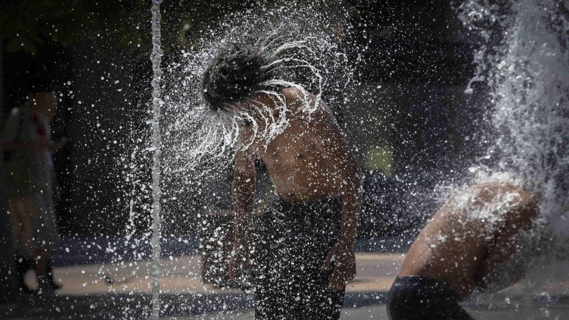 Dos jóvenes, refrescándose recientemente en la fuente de chorros de la Plaza de Yamaguchi en Pamplona