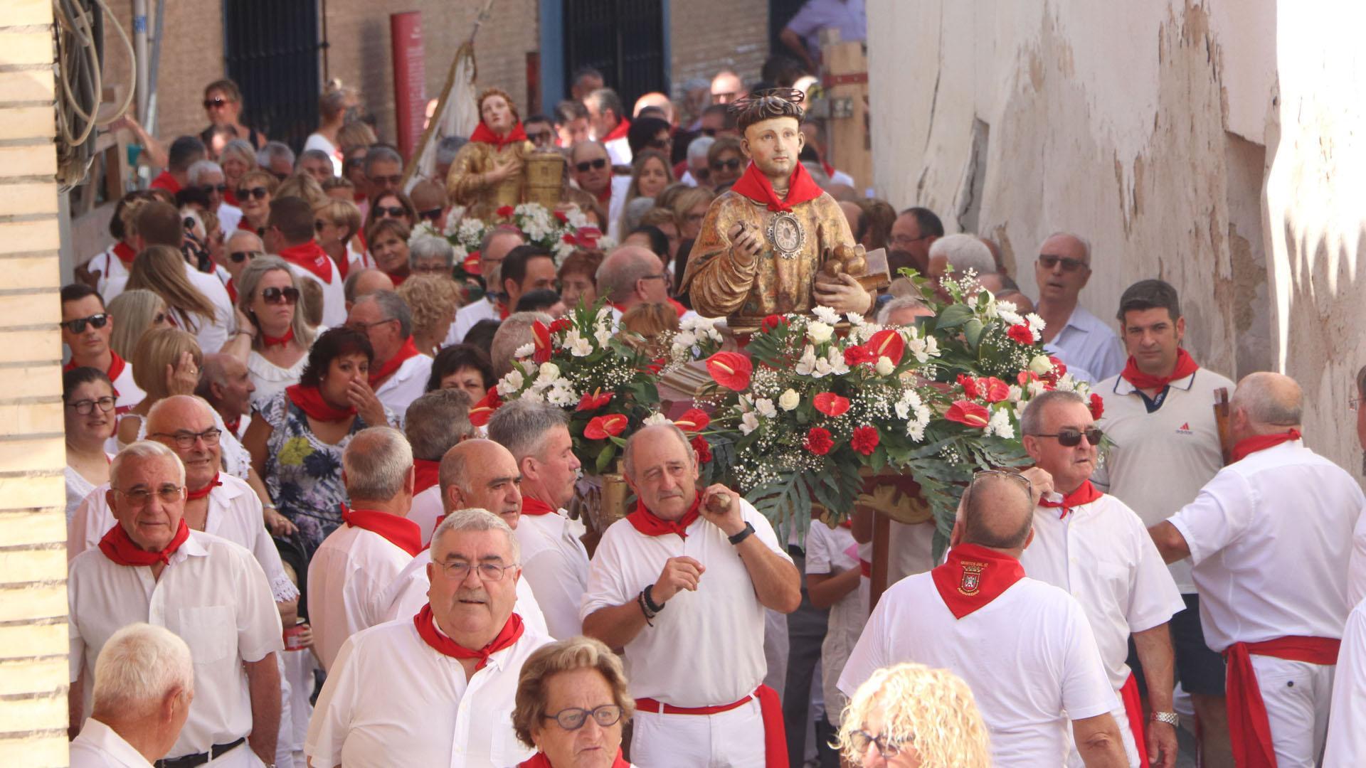 Las imágenes de San Esteban y Santa Bárbara, rodeadas de vecinos durante su desfile procesional