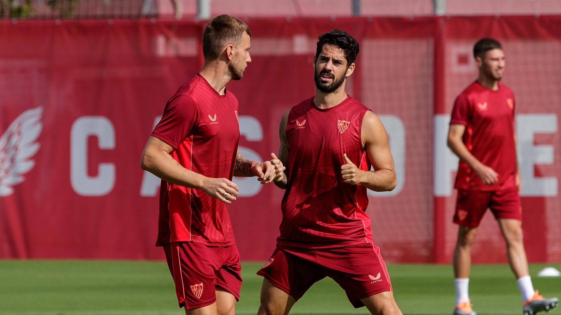 El centrocampista malagueño del Sevilla Isco Alarcón conversa con Rakitic durante el entrenamiento de este martes en el estadio Sánchez Pizjuán
