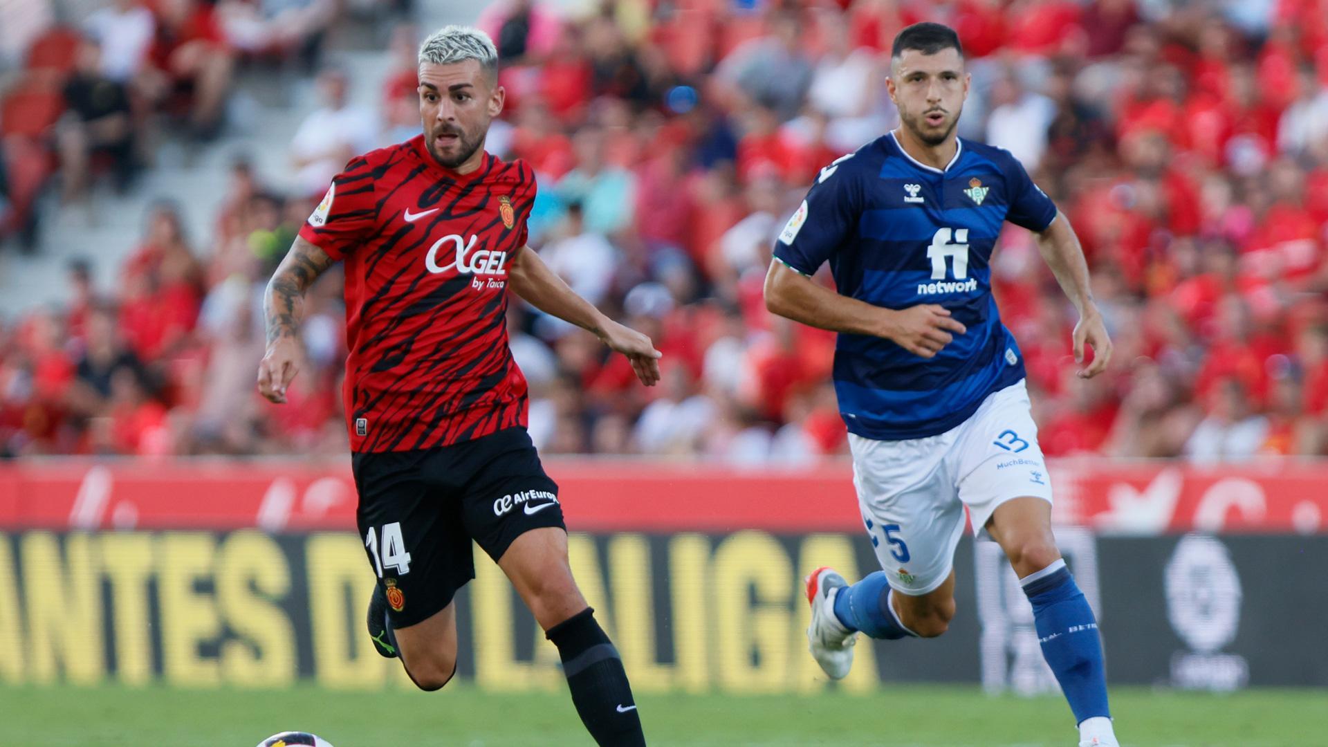 El centrocampista del Mallorca Dani Rodríguez (i) juega un balón ante Guido Rodríguez, del Betis, durante el partido