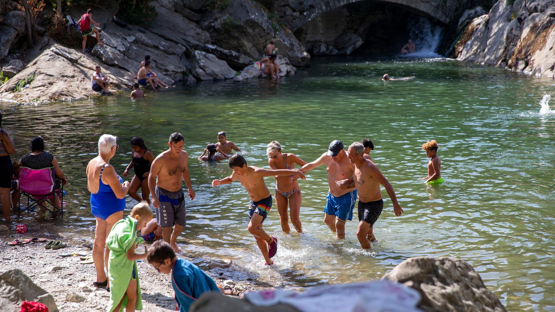 Varias personas se bañan en el río en Huarte a principios de agosto