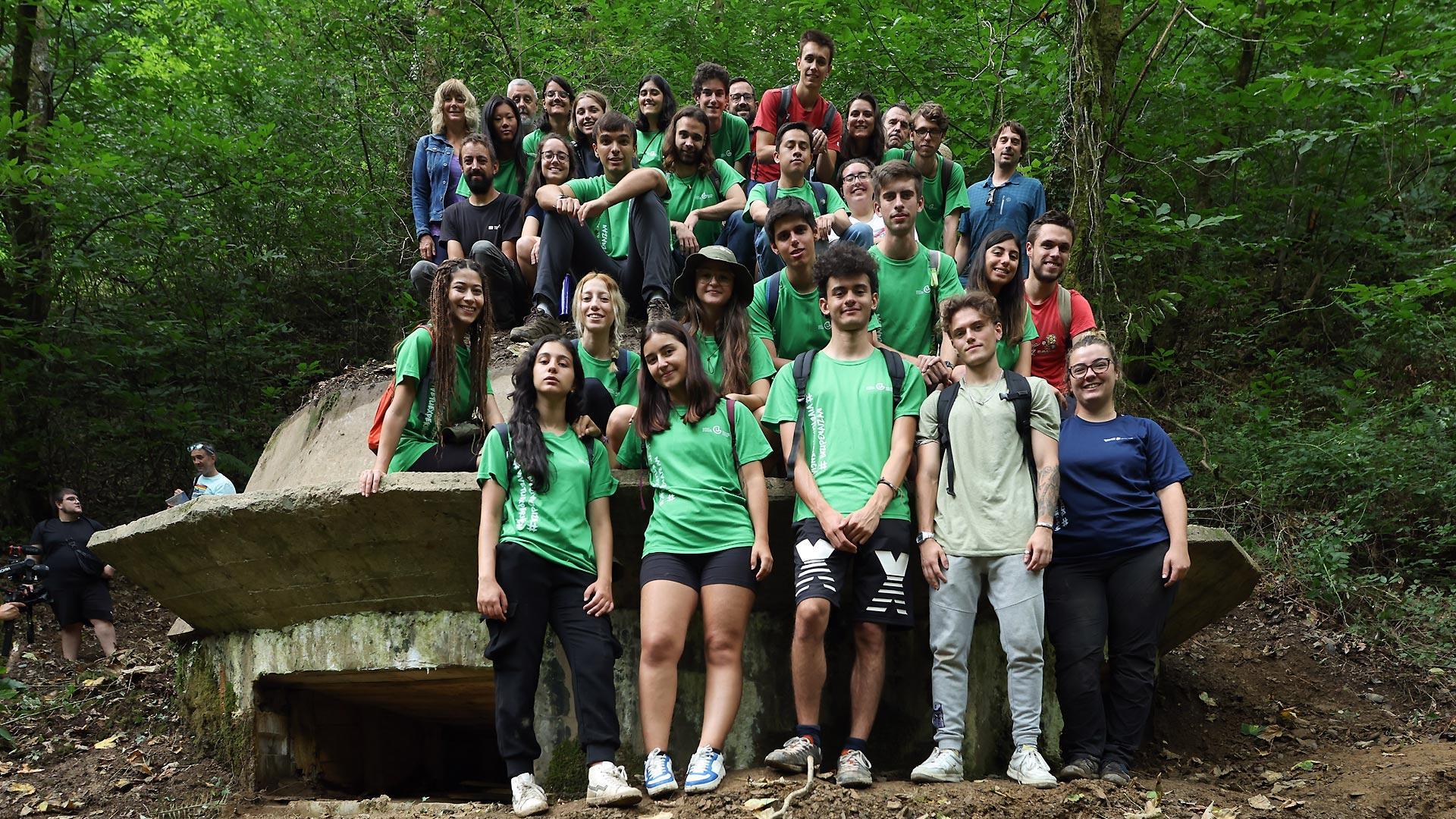 Los jóvenes participantes en el campo de voluntariado, junto a las autoridades que han visitado la zona