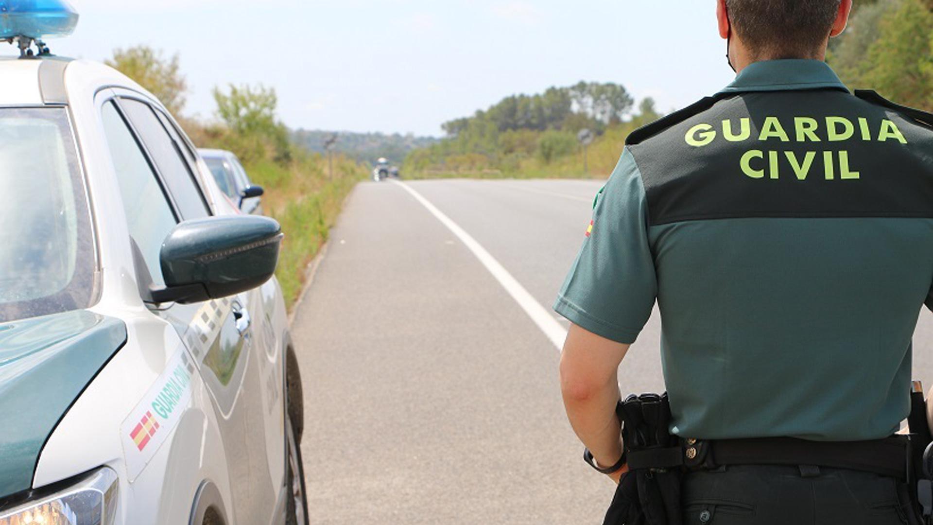 Un Guardia Civil junto a su vehículo en un control