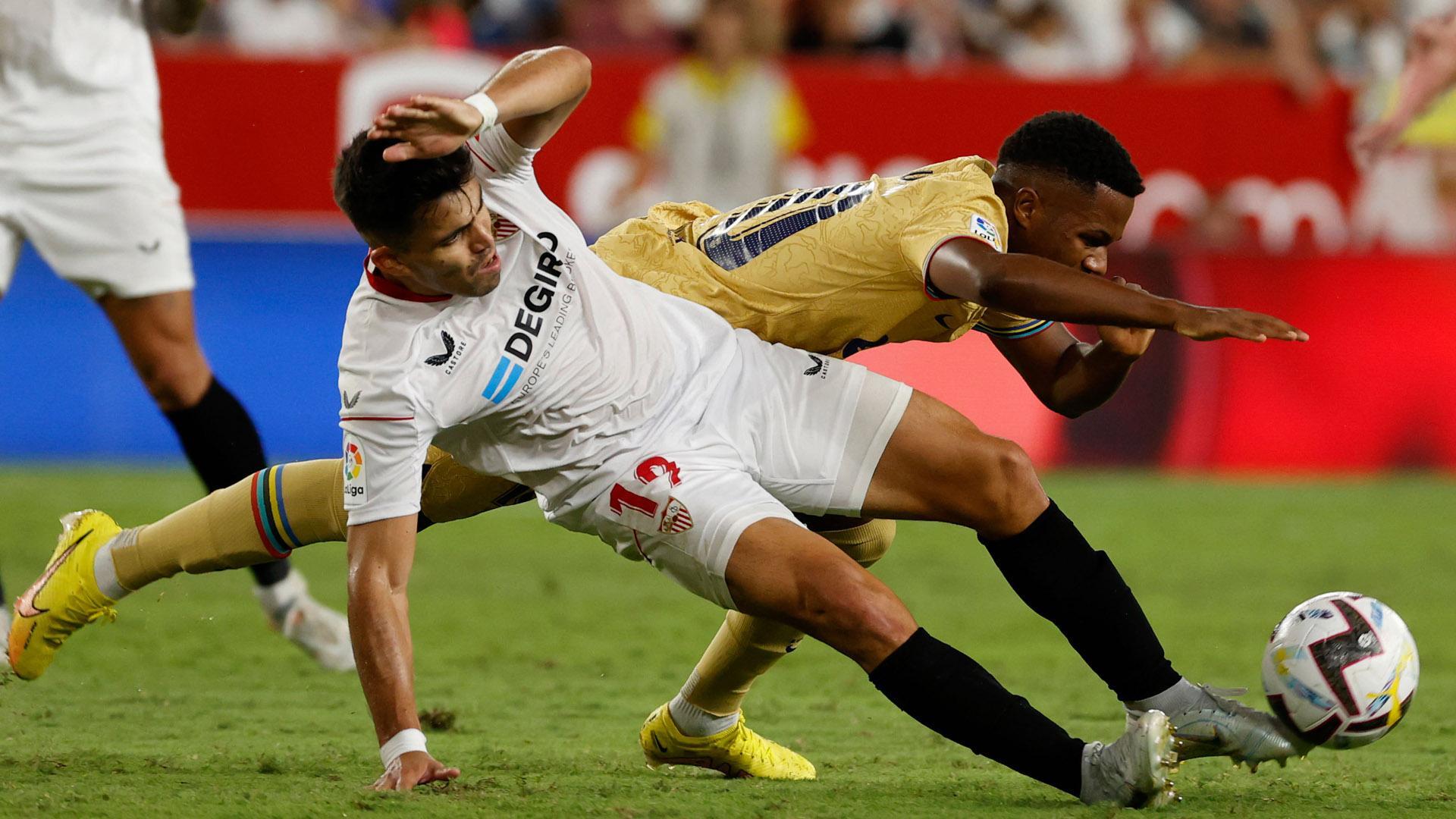 El defensa argentino Marcos Acuña (i), del Sevilla FC, lucha con Ansu Fati, del FC Barcelona, durante el partido de la cuarta jornada de LaLiga que Sevilla FC y FC Barcelona juegan este sábado en el estadio Sánchez-Pizjuán, en Sevilla