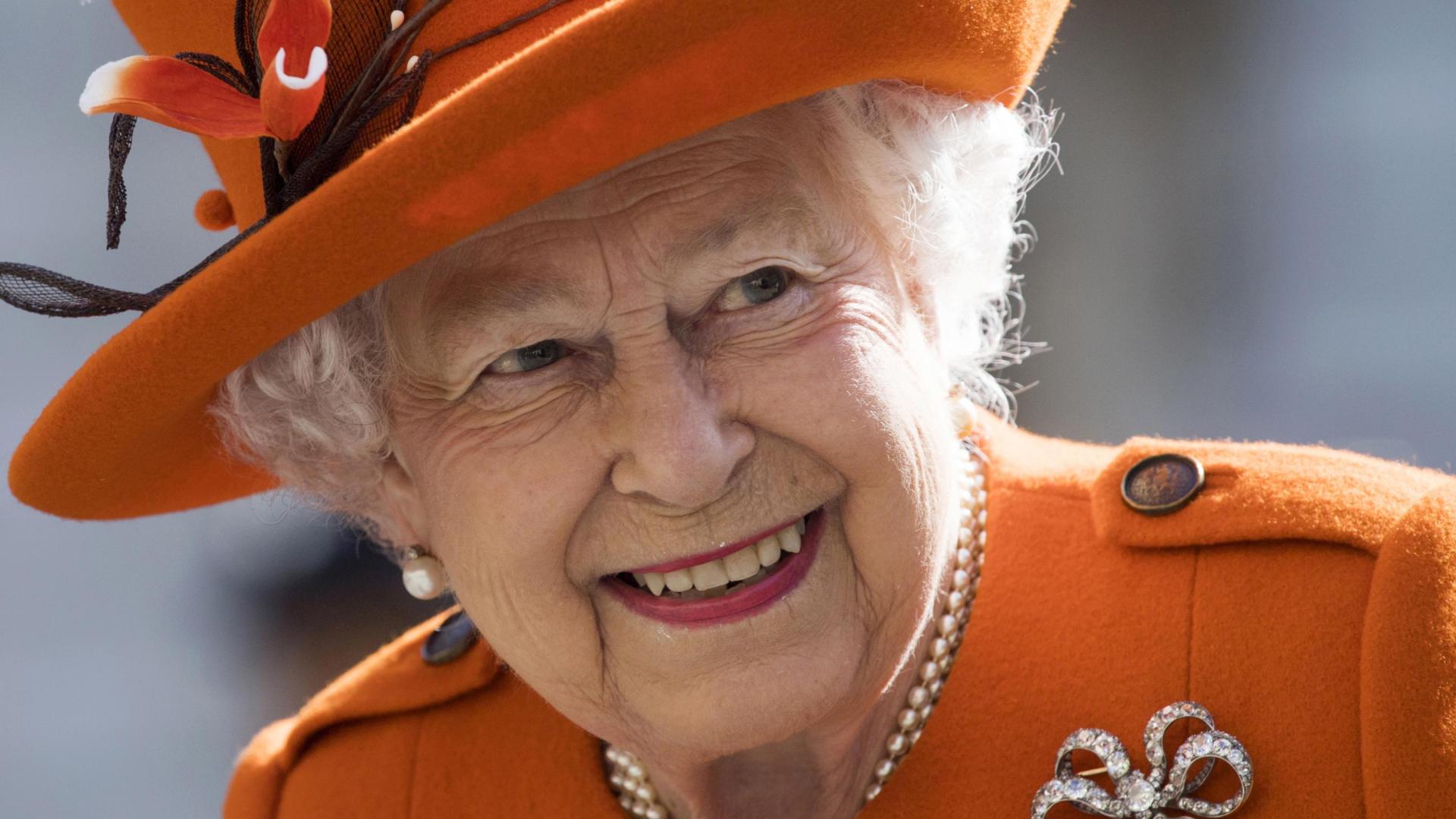 Imagen de la reina Isabel II, vestida con abrigo y sombrero naranja