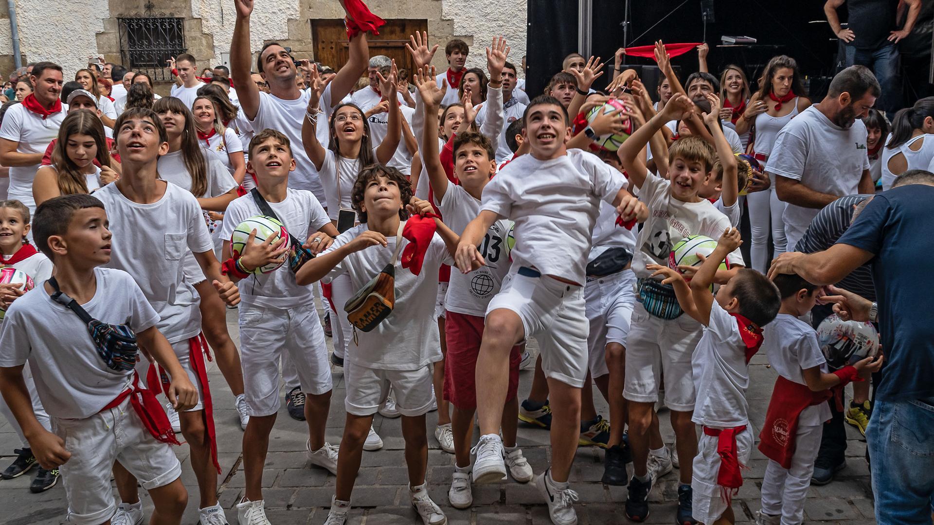 Los más jóvenes de Cirauqui saltaron para recoger los balones y caramelos que cayeron del balcón tras el cohete