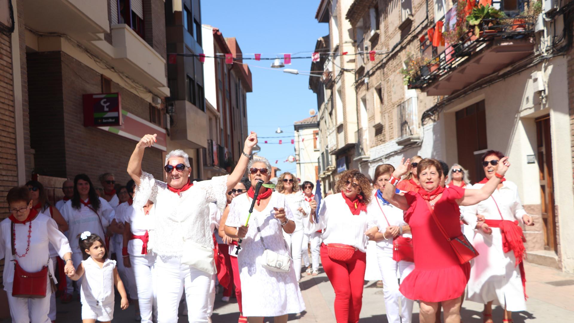 Un grupo de mujeres baila al son de la charanga en el pasacalles posterior a la misa.