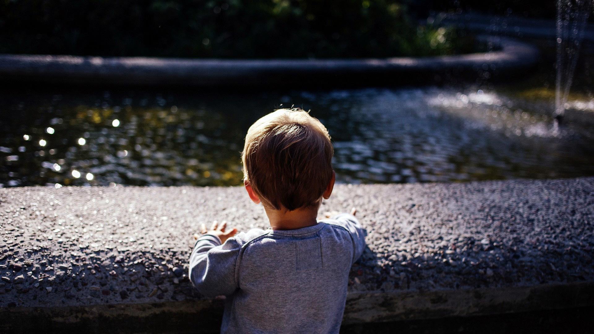 Un niño, frente a una fuente