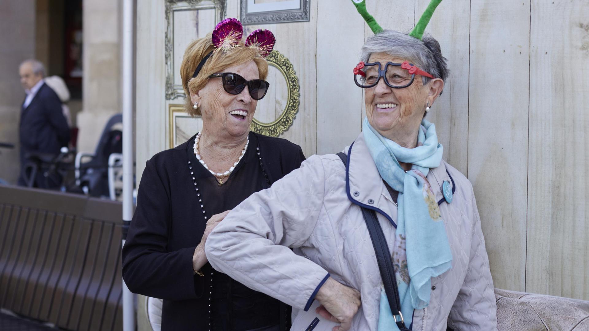 Dos mujeres participan en el photocall instalado en la Plaza del Castillo de Pamplona con motivo del Maratón contra la soledad