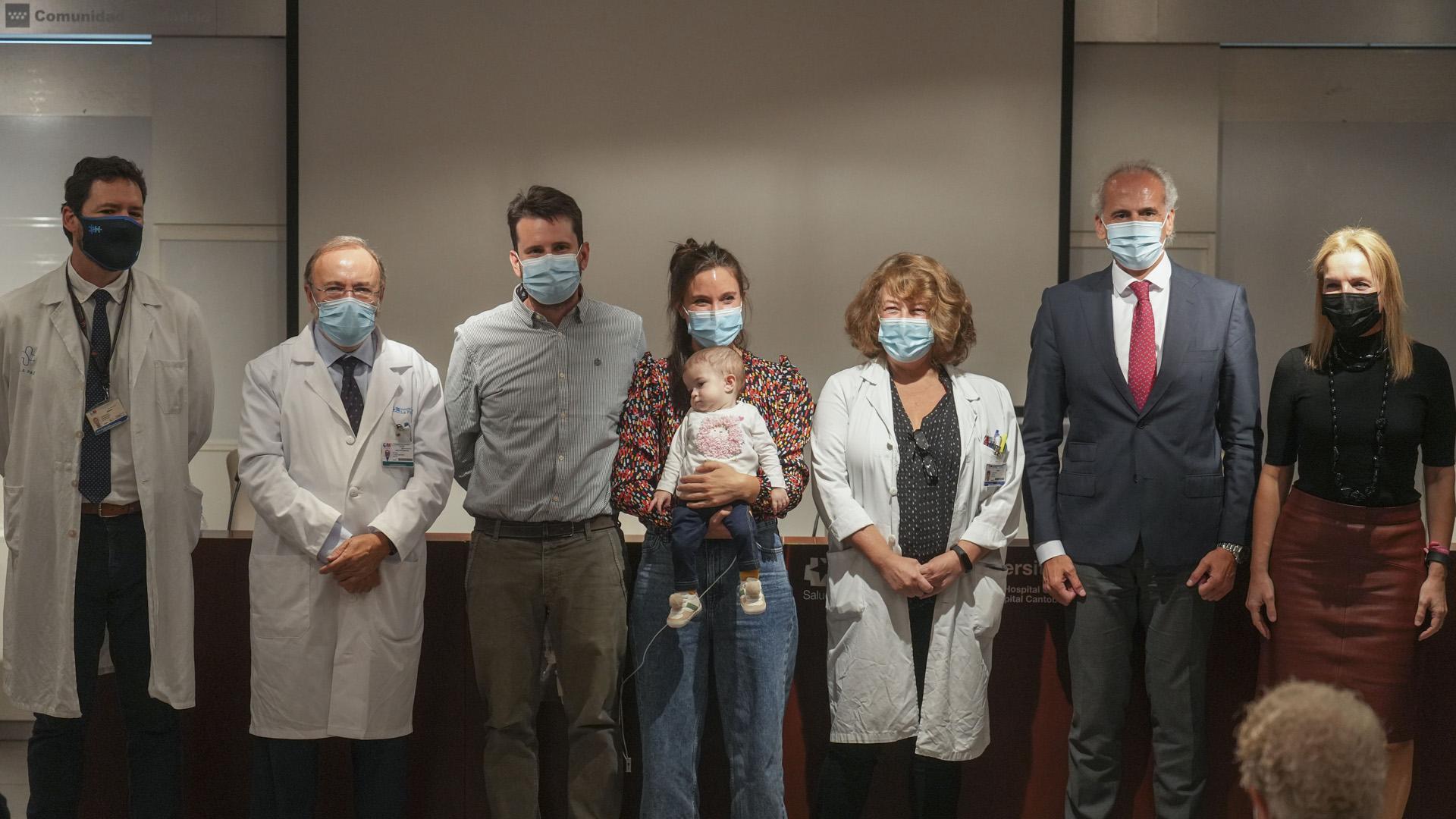 La pequeña Emma, de 13 meses, en brazos de su madre, Ana, acompañadas de su padre, Daniel, y las personas que han participado en el trasplante