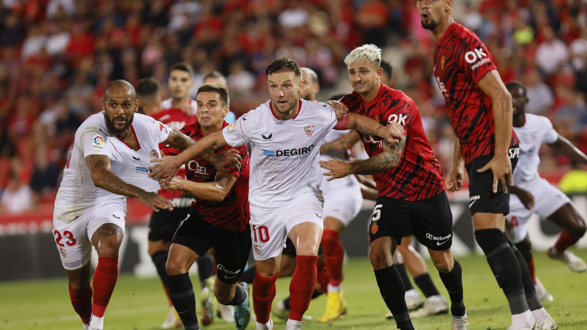 Los jugadores del Sevilla Ivan Rakitic (c) y Marcao (i) pelean la posicición con varios jugadores del Mallorca