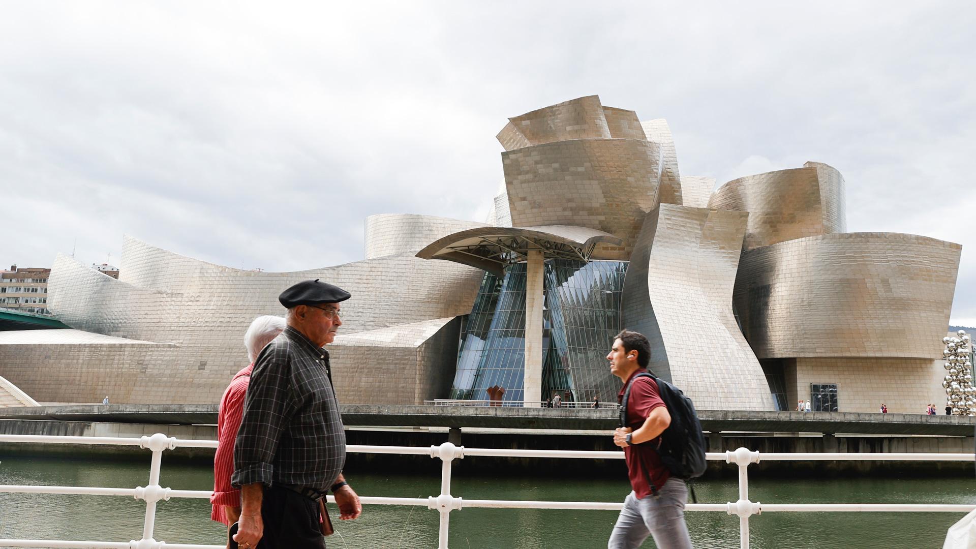 Varias personas pasan ante el Museo Guggenheim de Bilbao, obra del arquitecto Frank Gehry, que este año conmemora su 25 aniversario