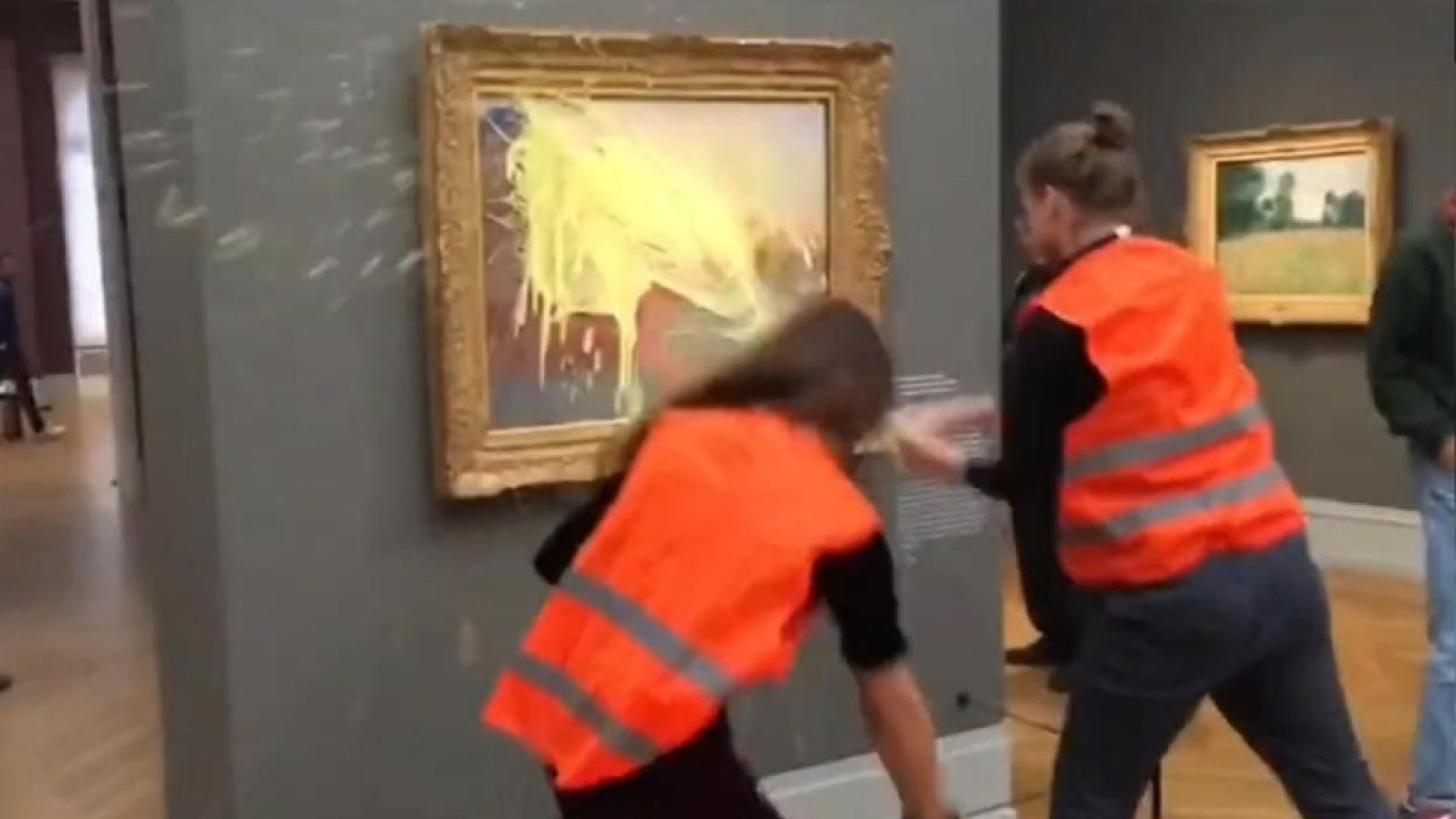 Momento en el que dos activistas lanzan puré de patatas al cuadro de Monet