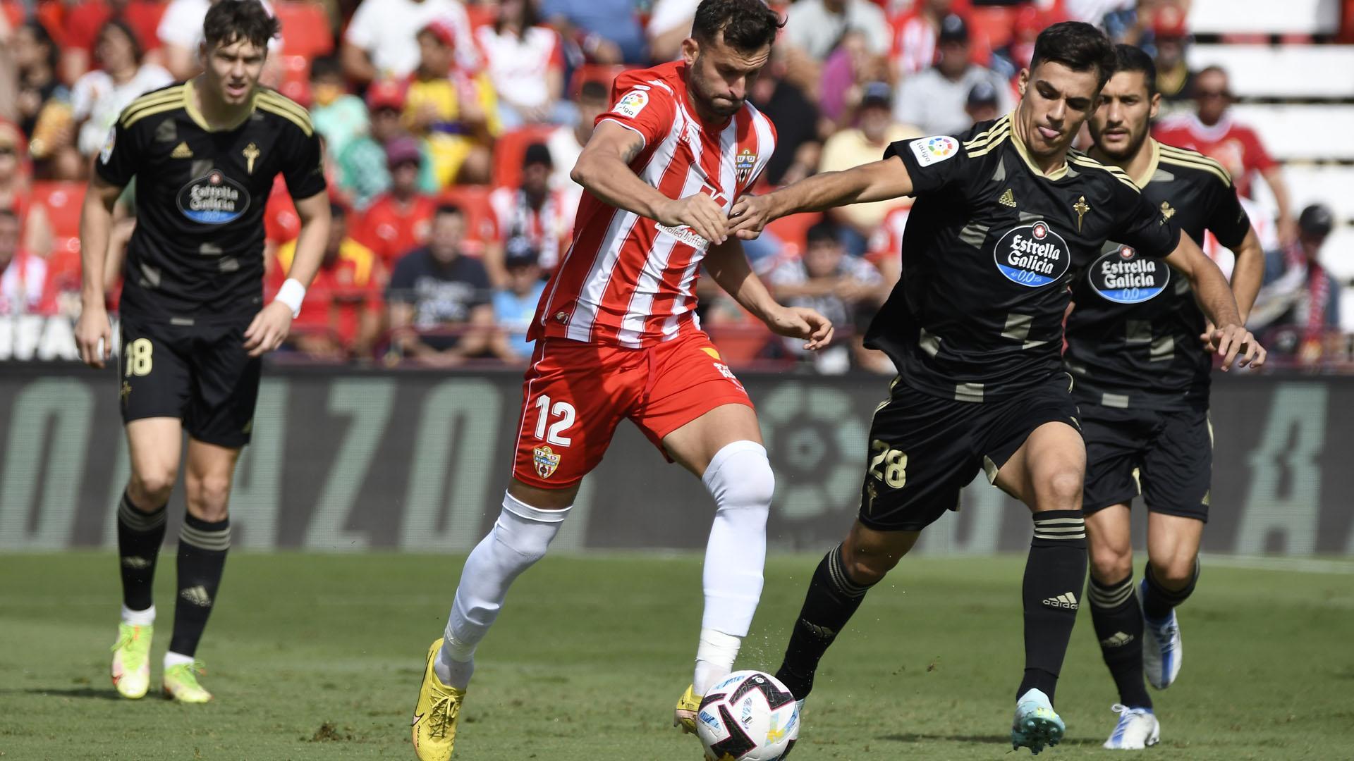El centrocampista brasileño del Almería Leo Baptistao con el balón ante el centrocampista del Celta de Vigo Gabriel Veiga (d)