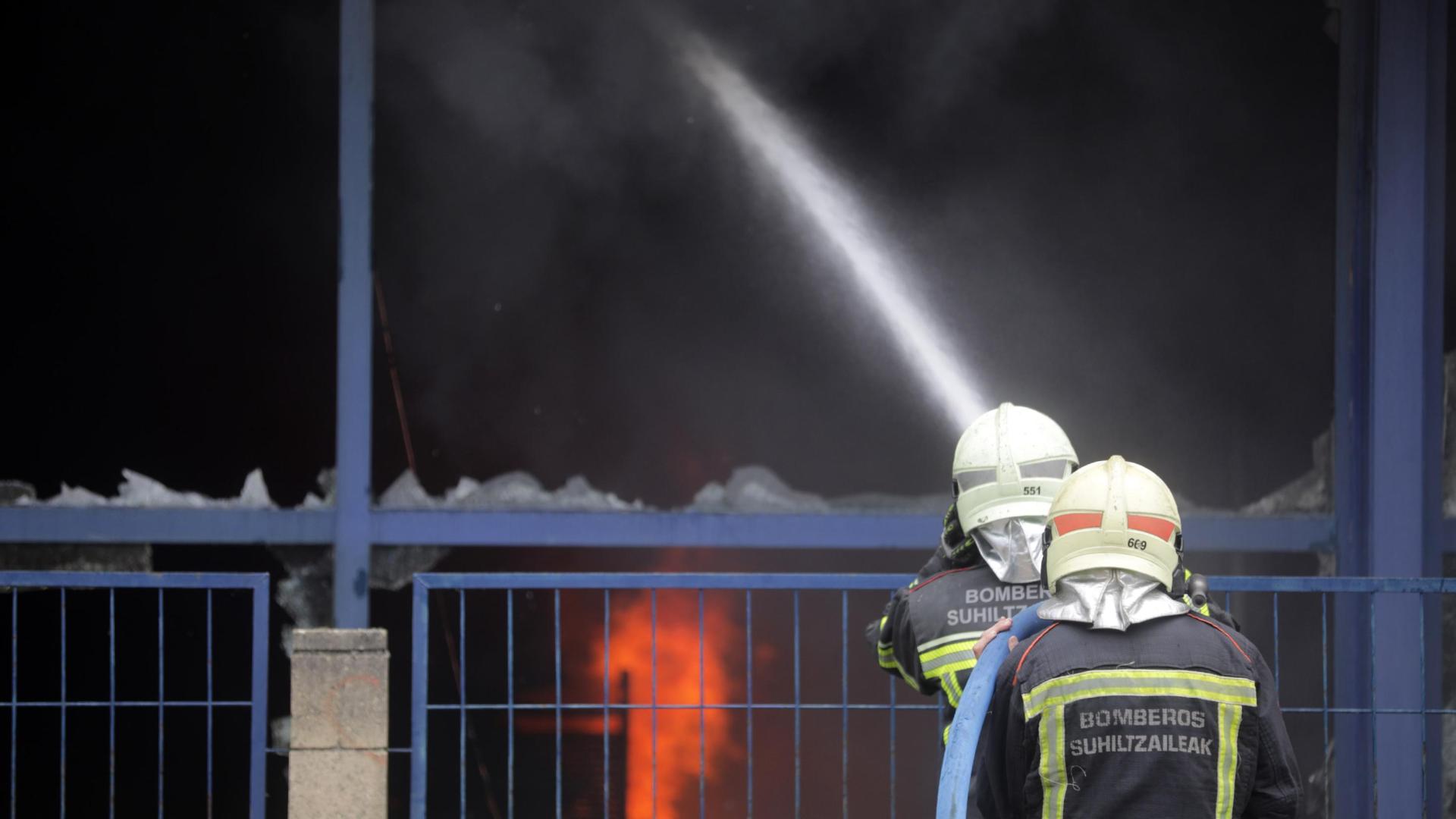 Dos bomberos participan en la extinción de un bazar en Burlada.