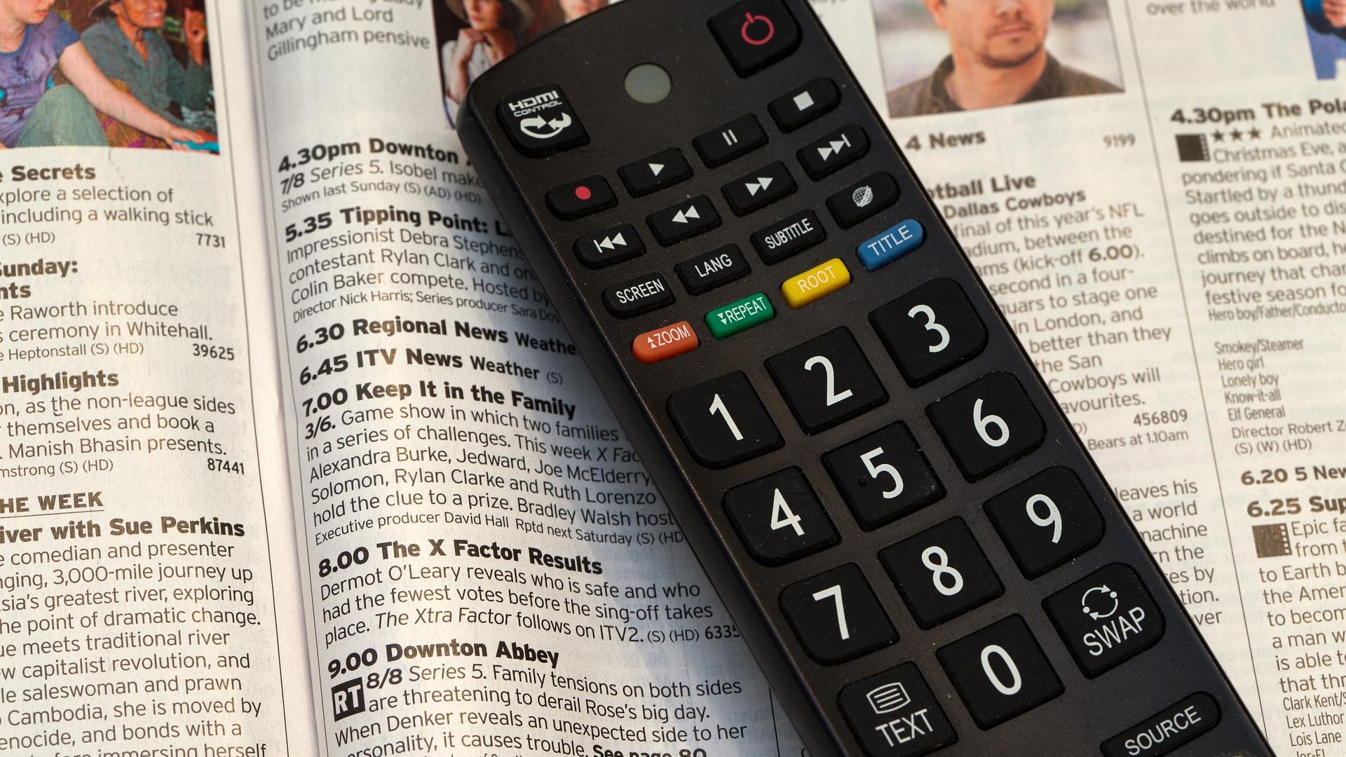 Imagen de un mando y la página de la guía televisiva de una revista