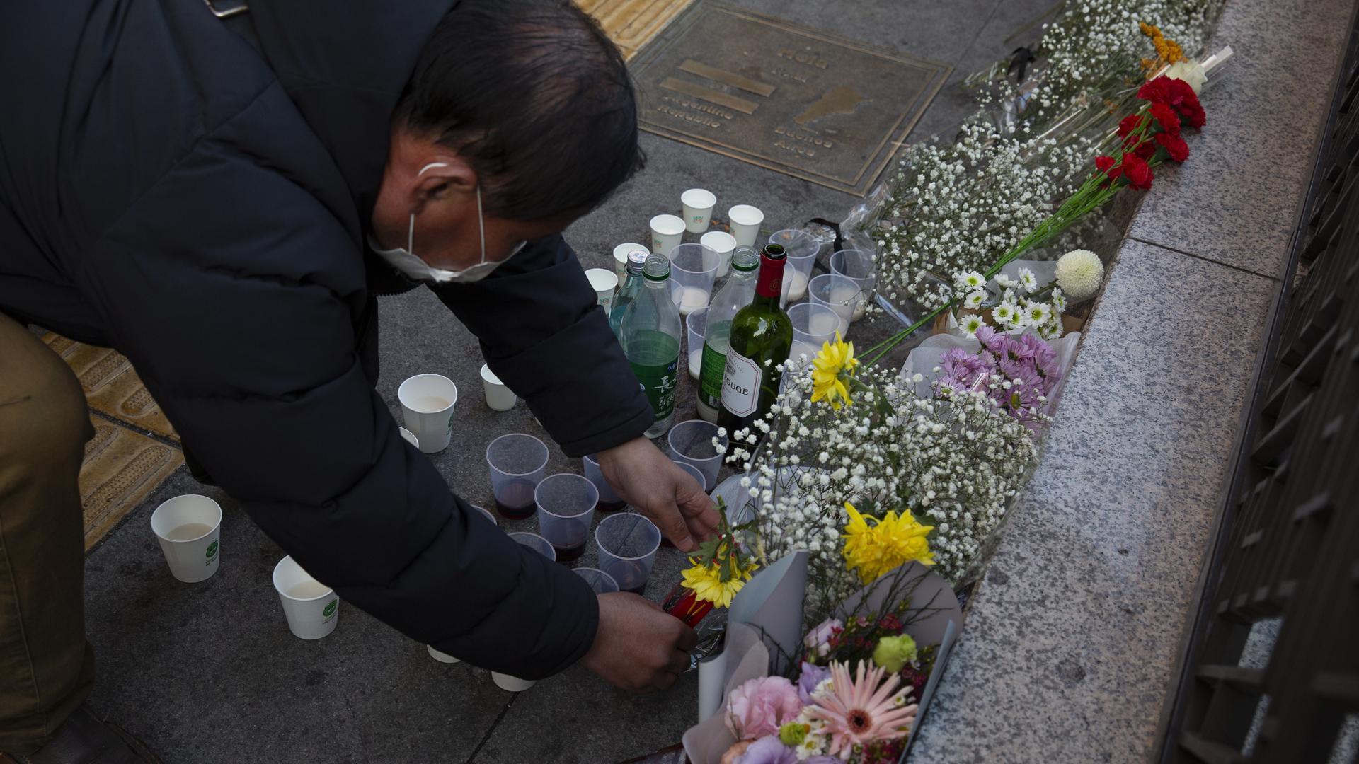 Un hombre deposita flores en el lugar de la tragedia