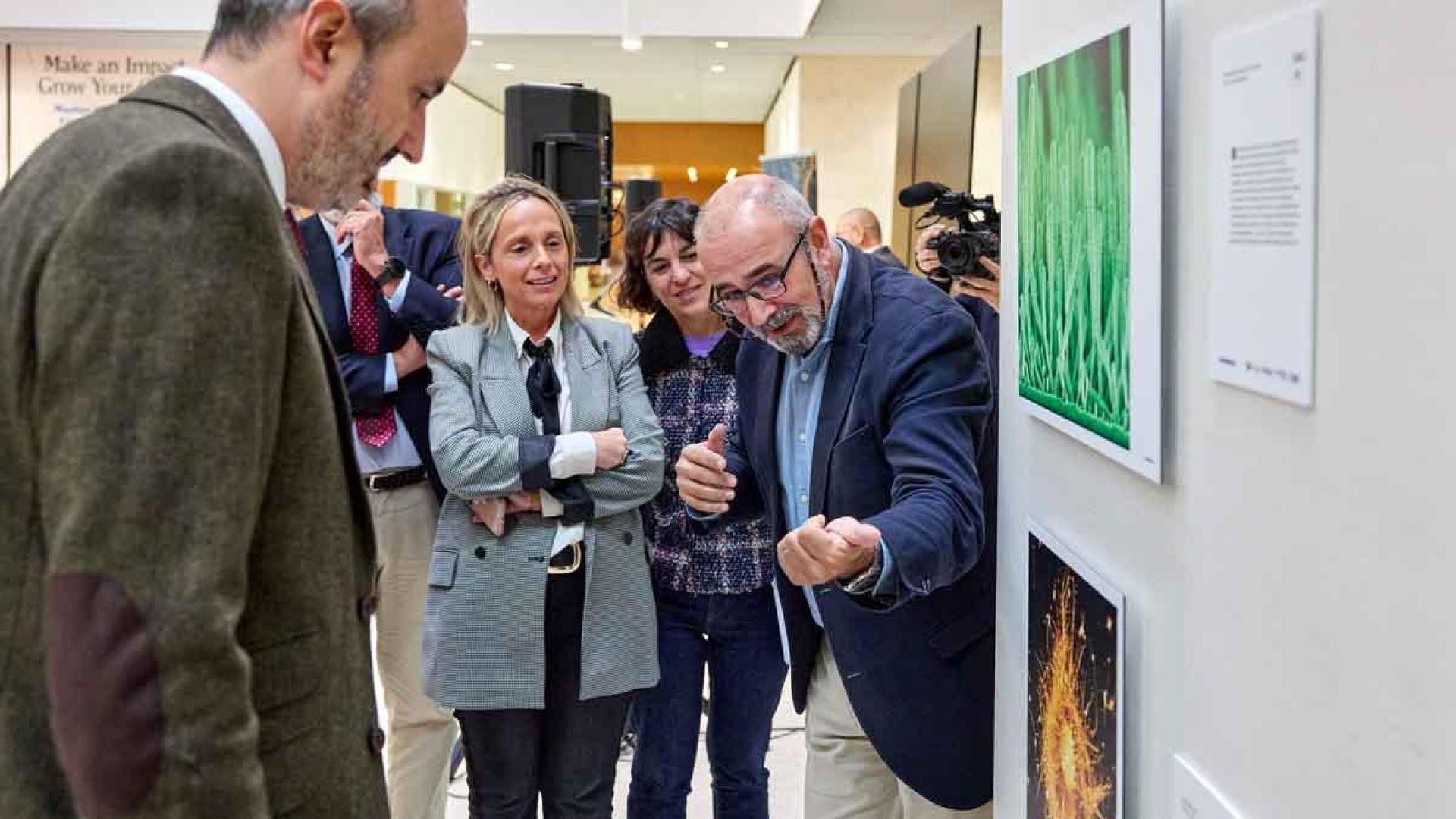 Ignacio López-Goñi, director del Museo de Ciencias de la UN, comenta las fotografías de Fotciencia ante el concejal Fermín  Alonso, la directora de Comunicación Científica de la UN, Elisa Montserrat y la directora de la Cátedra Mujer, Ciencia y Tecnología de la UPNA