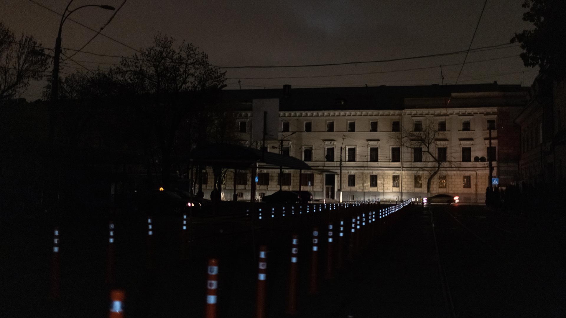 Una calle sin luz del centro de Kiev iluminada solo por los focos de un vehículo