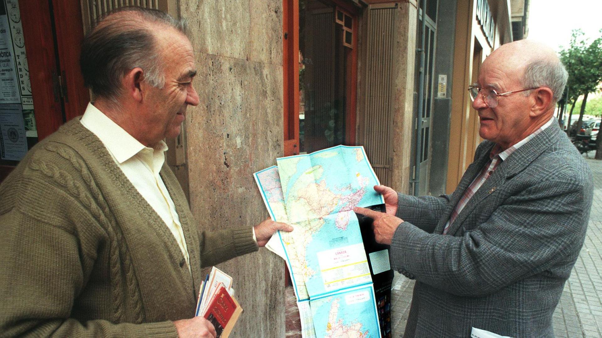 Douglas Cox señala un punto en un mapa, junto a Sebastián Anaut