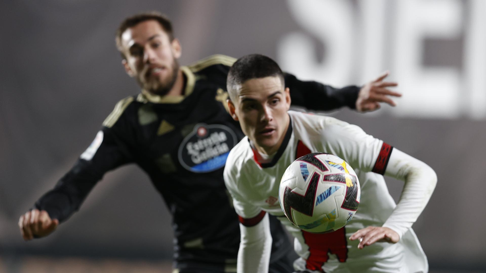 El delantero del Rayo Vallecano, Sergio Camello, con el balón ante el defensa del Celta, Óscar Mingueza