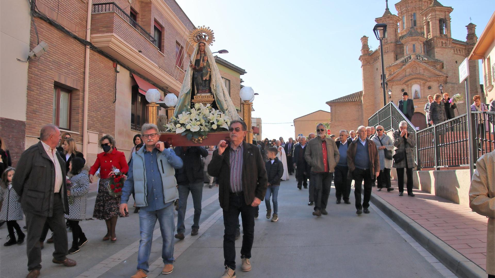 La imagen de Nuestra Señora del Patrocinio se dirige en procesión a la iglesia, arropada por los vecinos.