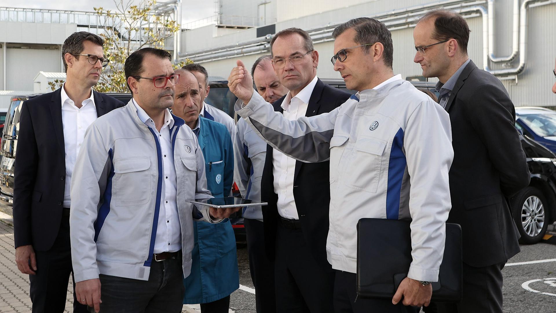 El director de Producción y Logística de Volkswagen, Christian Vollmer, en el centro de la imagen, atiende las explicaciones del presidente de Volkswagen Navarra, Michael Hobusch, en un momento de su visita a Volkswagen Navarra