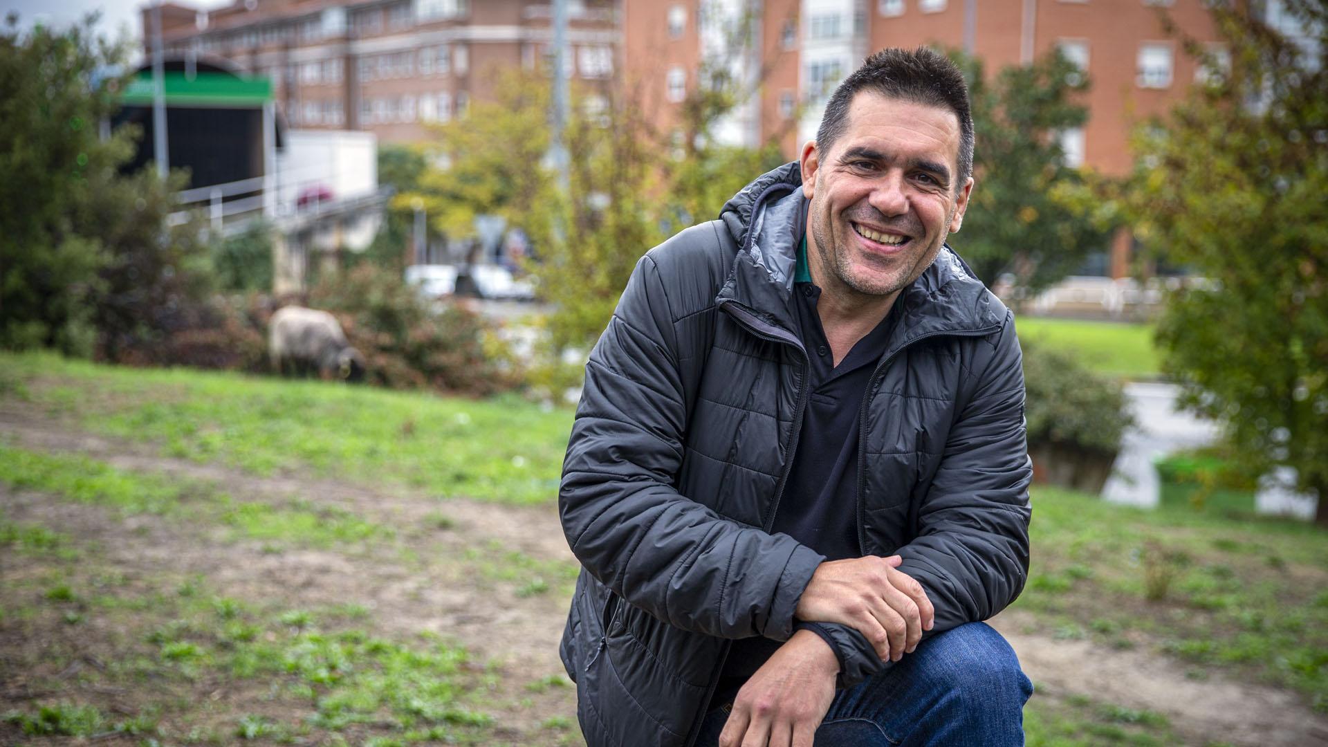 Alex “Txipi” Kormenzana Lumbreras a los pies de Ezkaba Txiki, su lugar de paseo habitual desde que llegó a la villa hace 28 años. Detrás una de las ovejas que limpian el monte