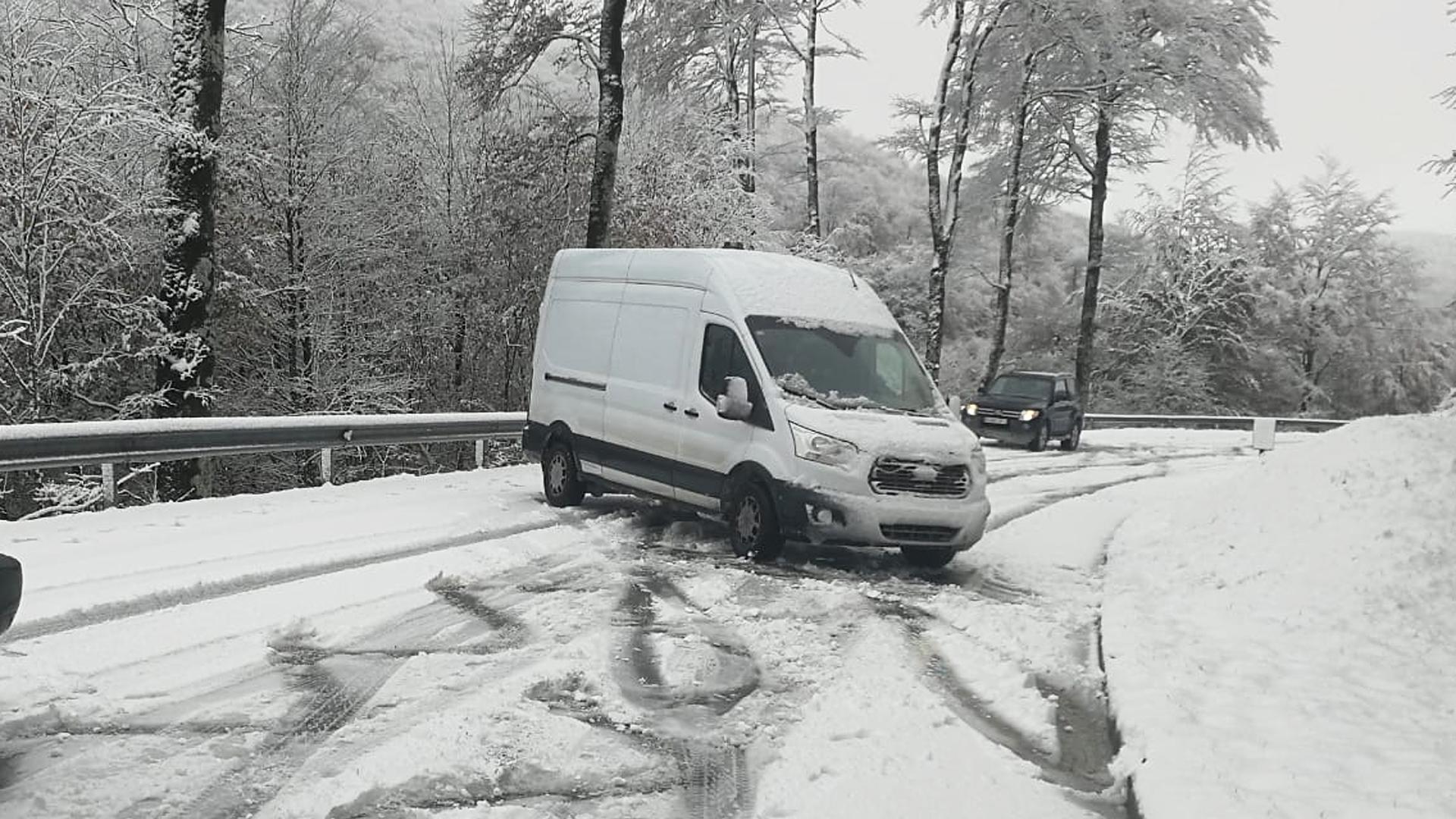 Una furgoneta cruzada en la carretera al puerto de Ibañeta por la presencia de nieve en la carretera