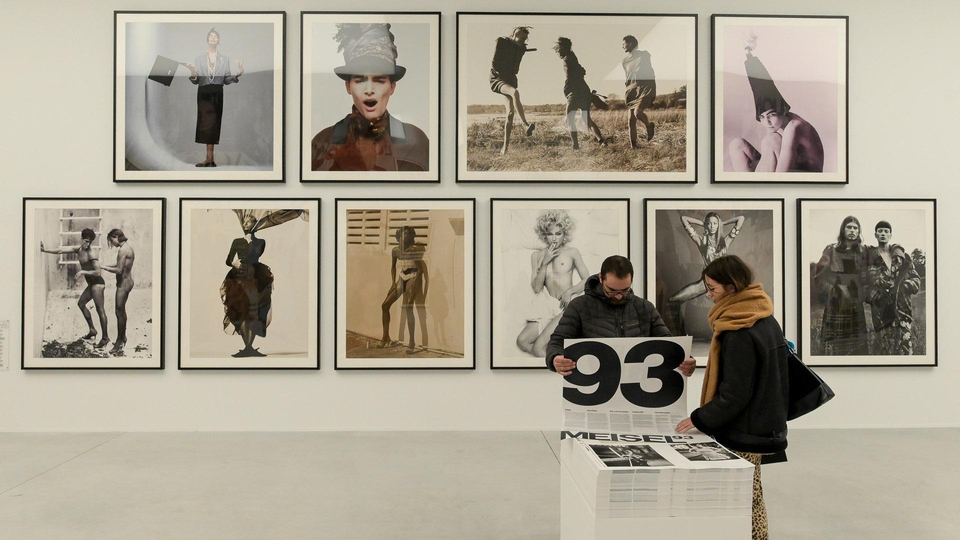 Dos personas observan las obras en la exposición `Steven Meisel 1993 A Year in Photographs¿ en el Muelle de la Batería de A Coruña, a 18 de noviembre de 2022, en A Coruña